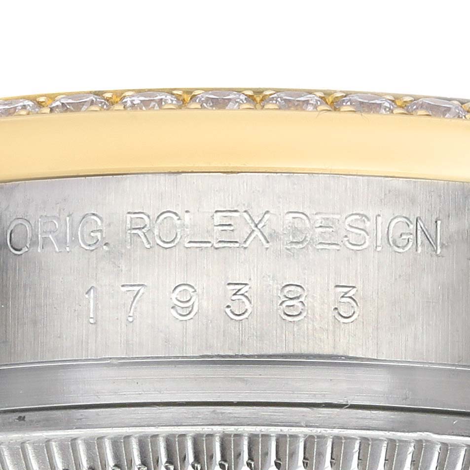 The image shows a close-up of the side engraving on the Rolex Datejust 179383 Women's Steel and Gold (two tone) White Dial 179383 Women's Steel and Gold (two tone) White Dial, featuring part of the bezel with diamonds.