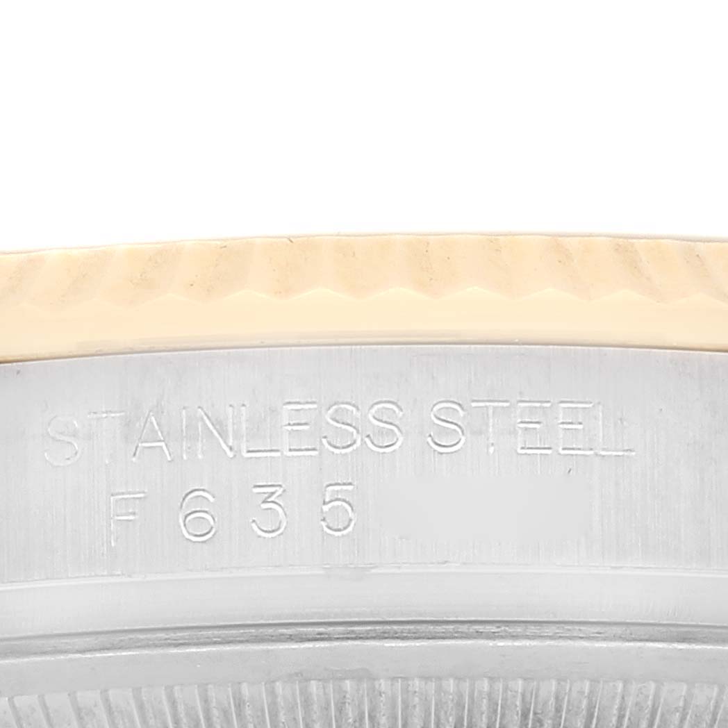 This close-up shows the side of a Rolex Datejust 116233 Men's Steel and Gold (two tone) White Dial 116233 Men's Steel and Gold (two tone) White Dial watch, focusing on the stainless steel bezel and engraved model details.