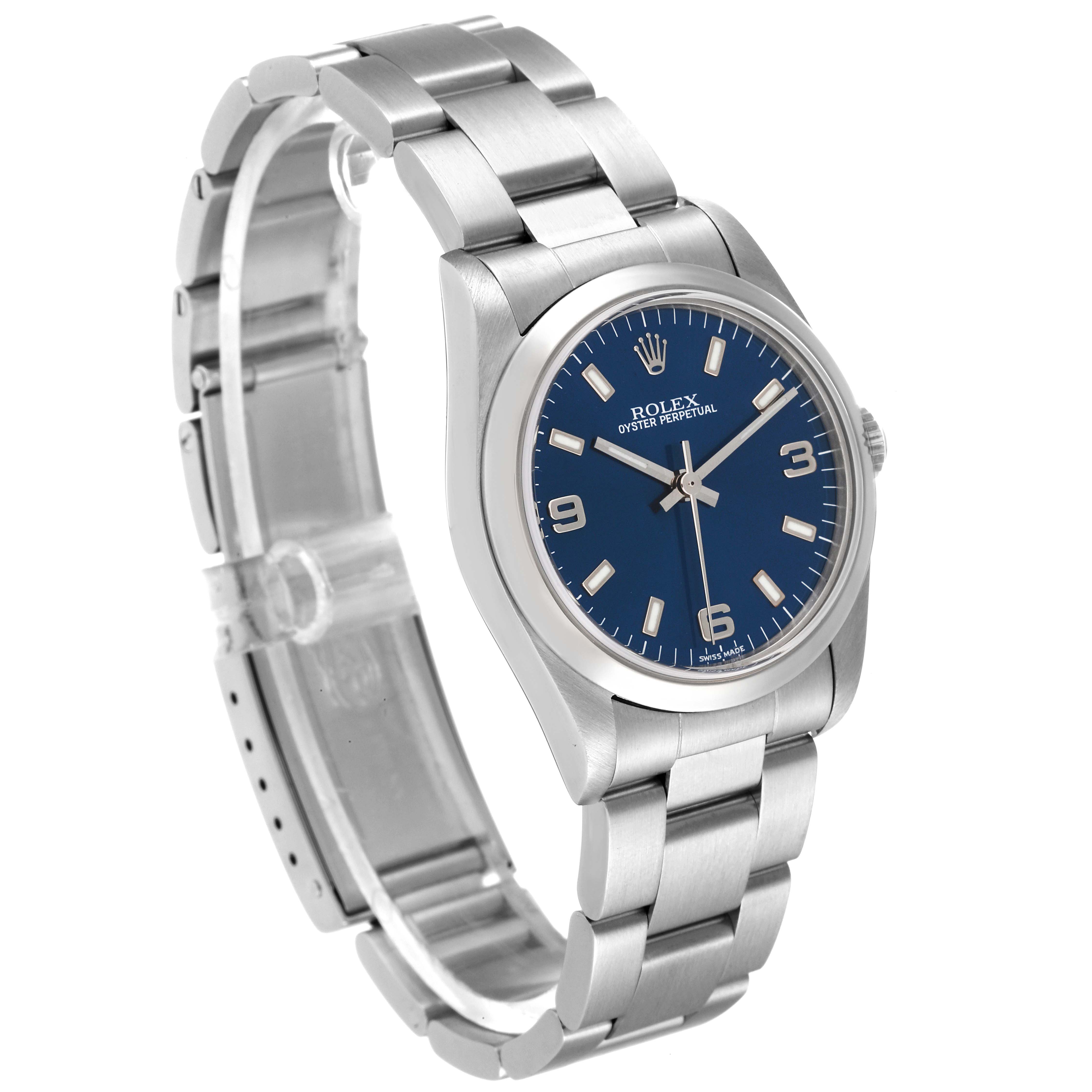 The Rolex Mid-Size 77080 Women
s Stainless Steel Blue Dial 77080 Women
s Stainless Steel Blue Dial Oyster Perpetual watch is shown at an angled side profile highlighting its dial, bracelet, and clasp.