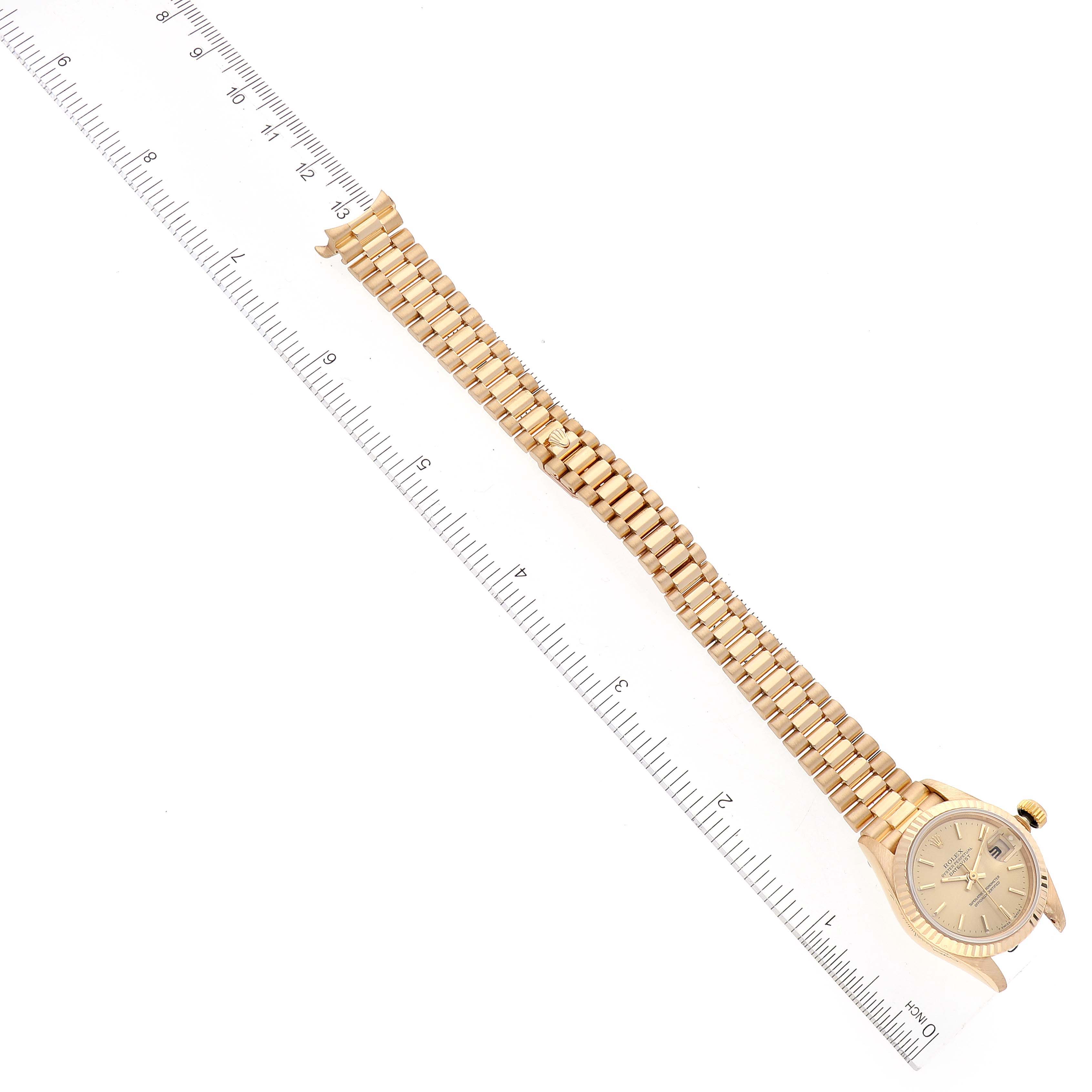The image shows a side view of the Rolex President 69178 Women's Yellow Gold Champagne Dial 69178 Women's Yellow Gold Champagne Dial model watch, featuring the bracelet and part of the case with a ruler placed beside.