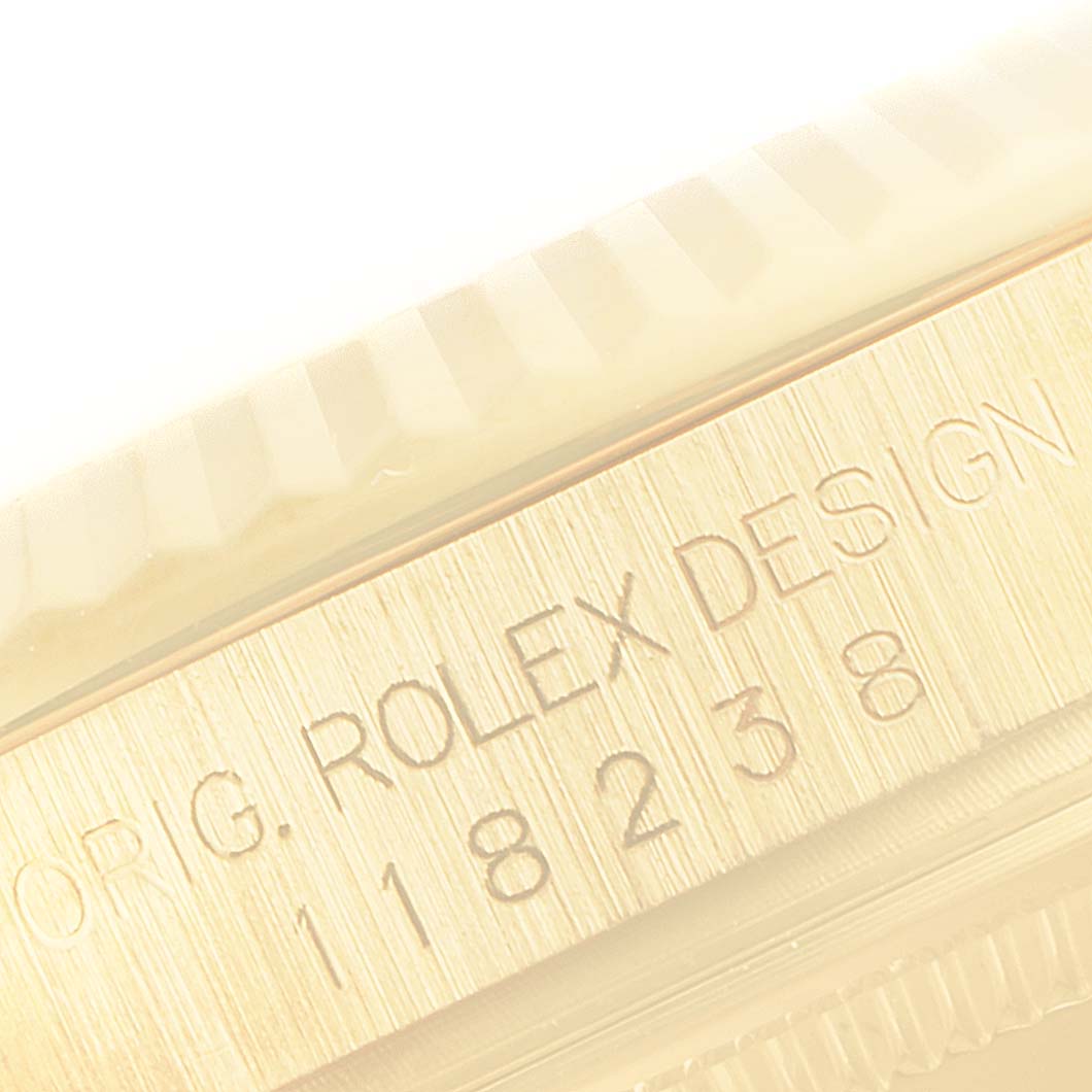 The image shows a close-up of the side of a Rolex President 118238 Men
s Yellow Gold Champagne Dial 118238 Men
s Yellow Gold Champagne Dial model, highlighting its engraved branding and part of the bezel.
