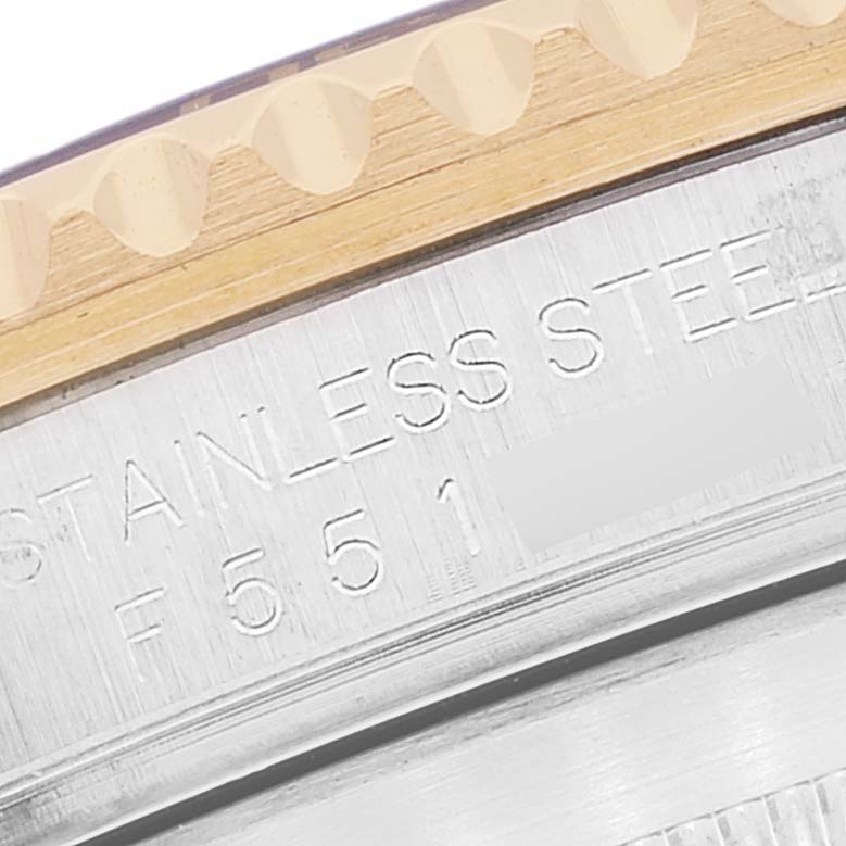 The image shows a close-up of the side of a Rolex Submariner 16613 Men's Steel and Gold (two tone) Blue Dial 16613 Men's Steel and Gold (two tone) Blue Dial model, highlighting the stainless steel engraving and part of the bezel.