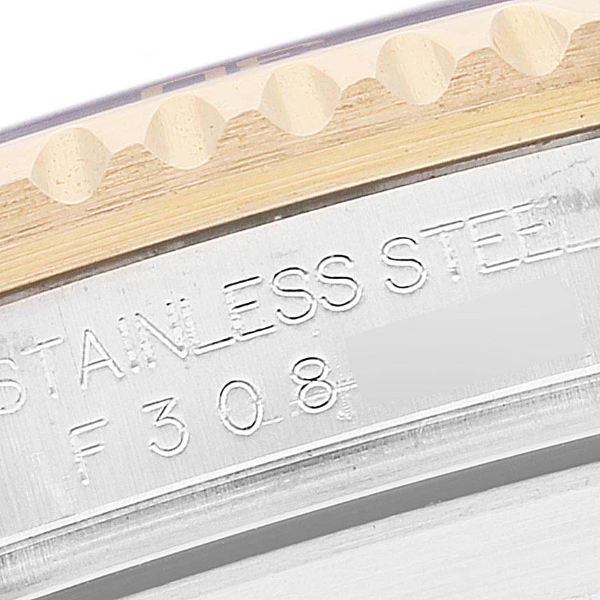 This close-up image shows the engraved stainless steel marking on the case edge and bezel teeth of the Rolex Submariner 16613 Men's Steel and Gold (two tone) Blue Dial 16613 Men's Steel and Gold (two tone) Blue Dial.
