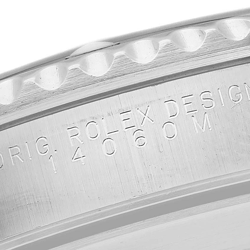 This image shows a close-up of the engraved outer rim of a Rolex Submariner 14060M Men
s Stainless Steel Black Dial 14060M Men
s Stainless Steel Black Dial watch.