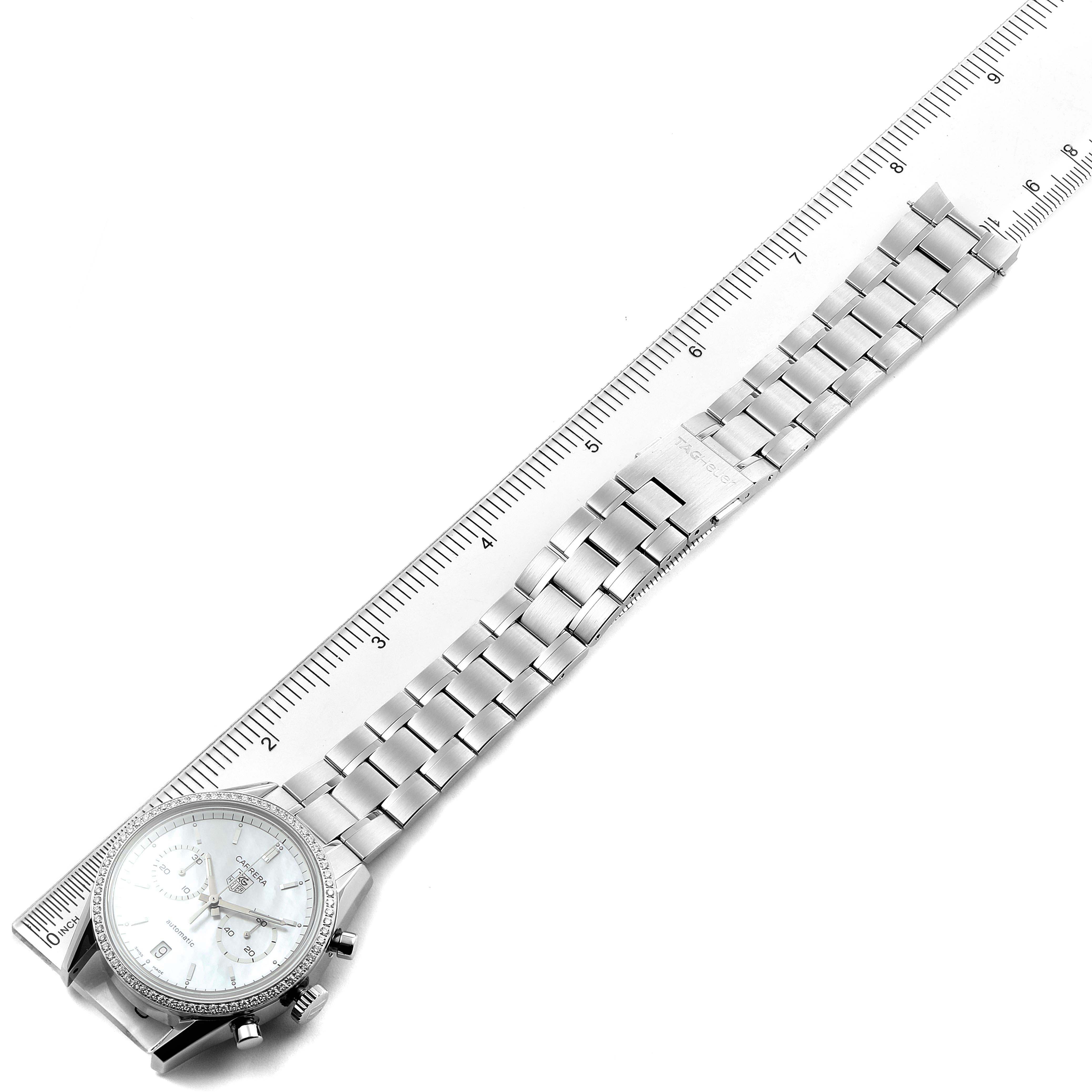 The image shows a Tag Heuer Carrera CV2116 Men's Stainless Steel Mother of Pearl Dial CV2116 Men's Stainless Steel Mother of Pearl Dial model watch laying flat, displaying its face and metal strap alongside a ruler for measurement.