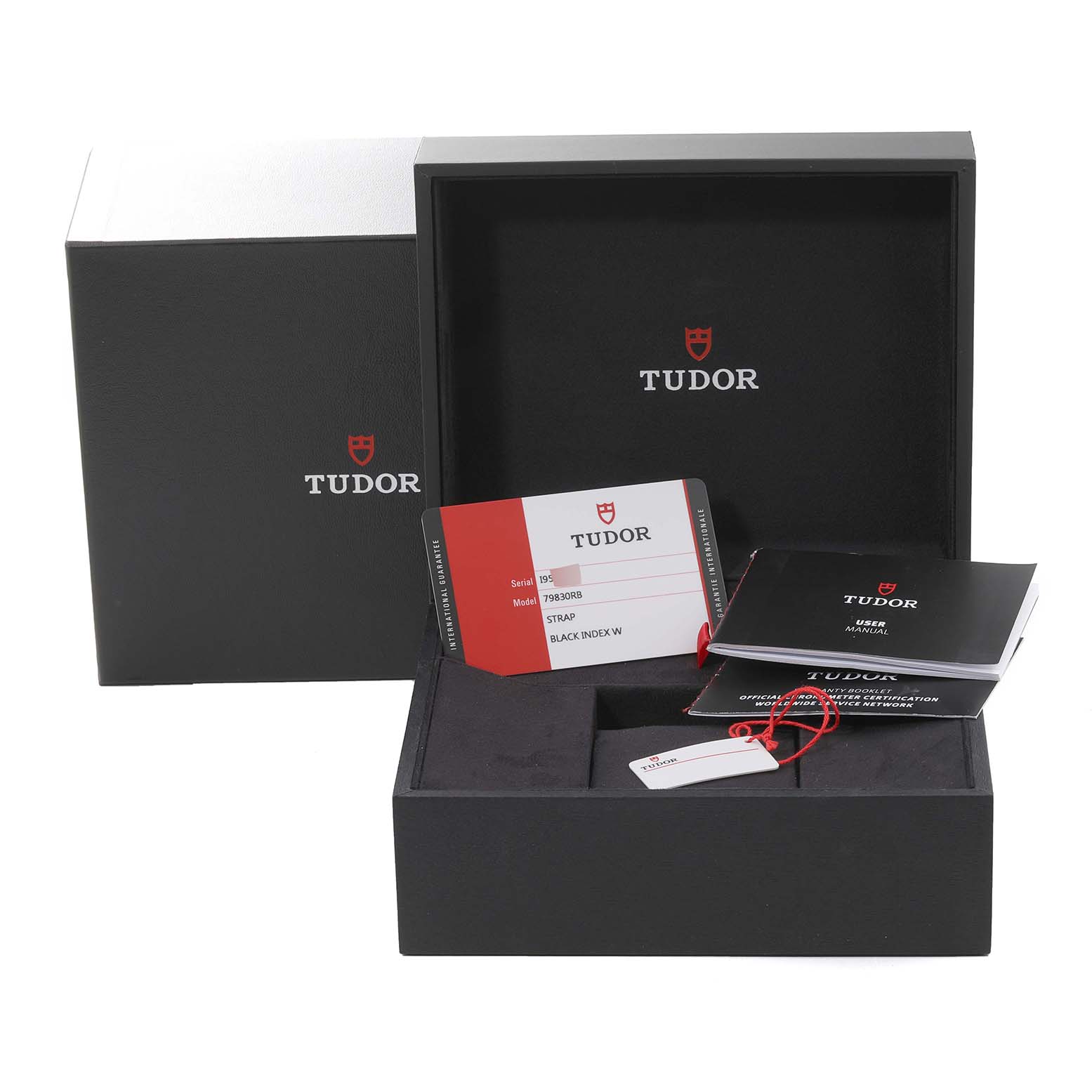 The image shows the packaging and accessories of the Tudor Heritage Black Bay 79830RB Men
s Stainless Steel Black Dial 79830RB Men
s Stainless Steel Black Dial watch, including the box, manuals, and warranty card.