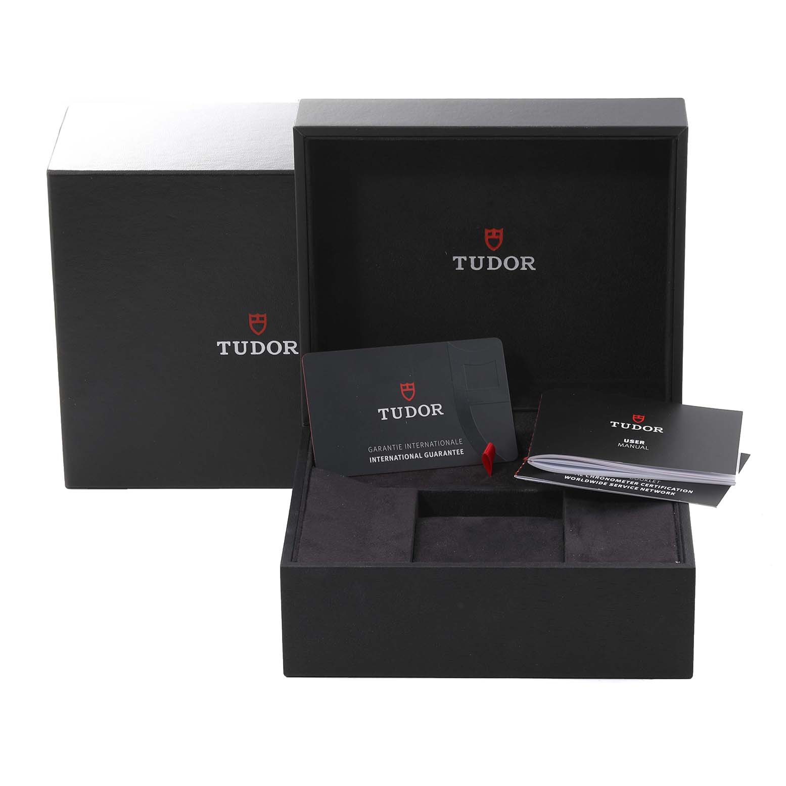 The image shows the open packaging box for the Tudor Pelagos 25610TNL Men
s Titanium Black Dial 25610TNL Men
s Titanium Black Dial, including the guarantee card and manual, viewed from the front.