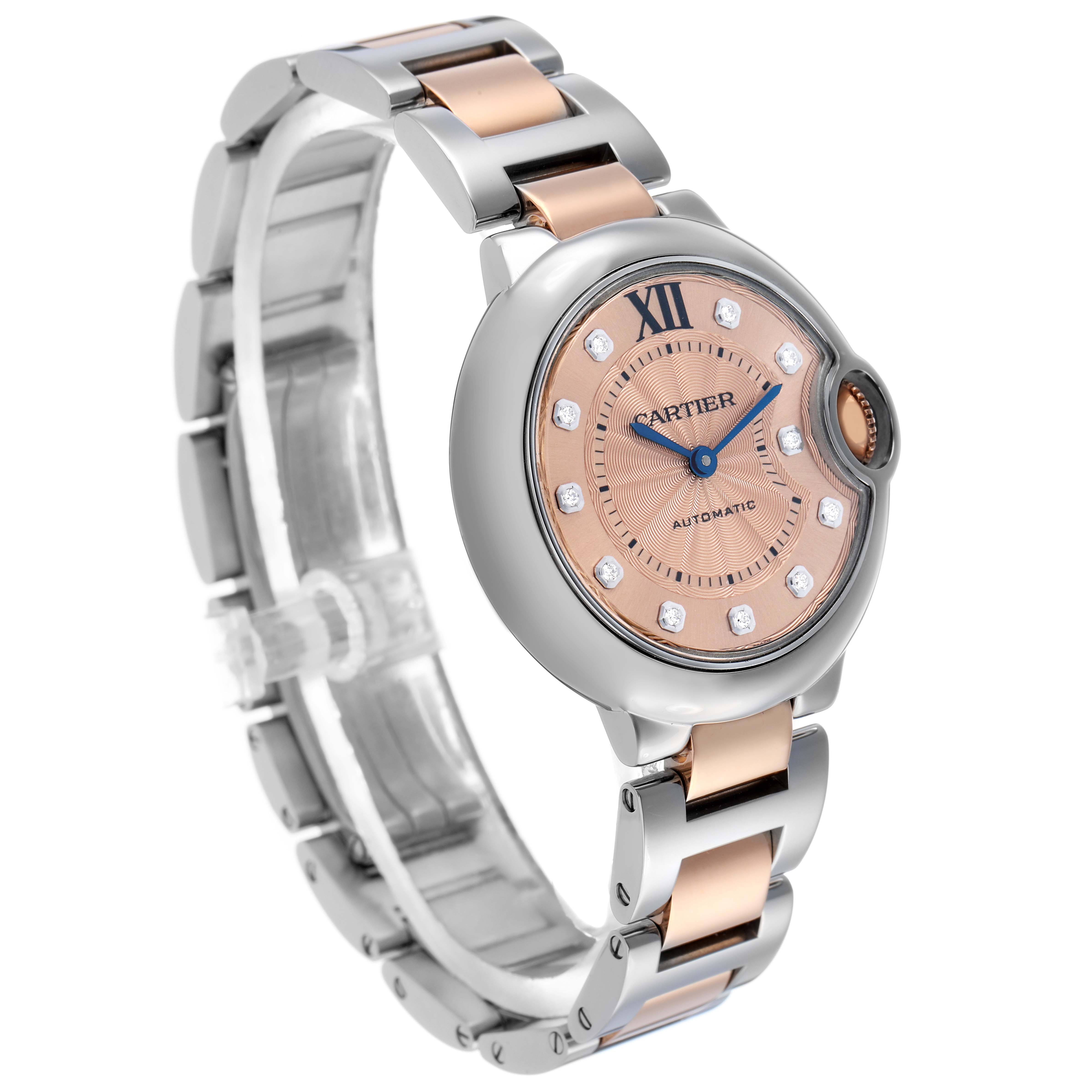 The Cartier Ballon Bleu WE902053 Women's Steel and Gold (two tone) Pink Dial watch is shown from an angled view, highlighting its pink dial, Roman numeral, and two-tone bracelet.