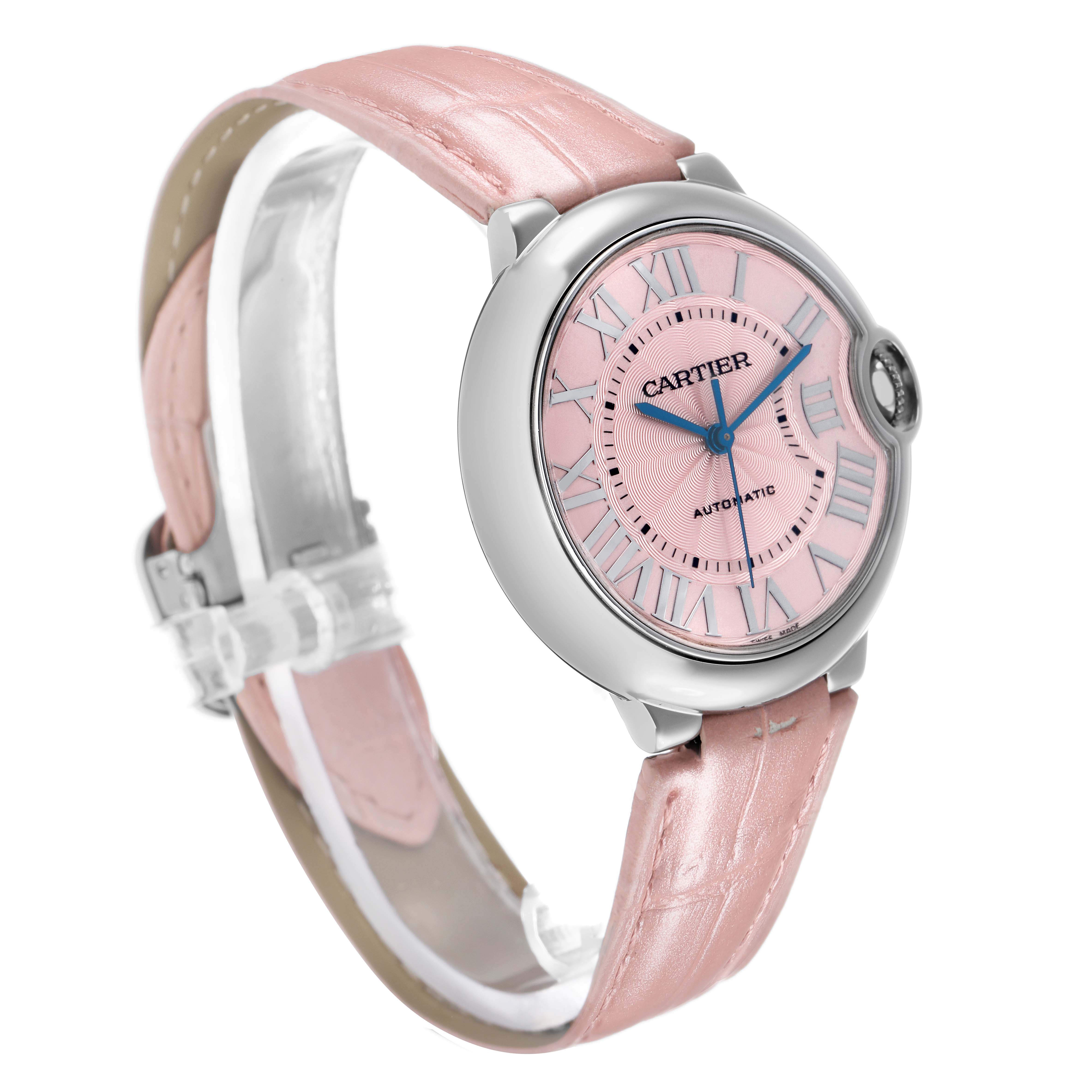 The Ballon Bleu by Cartier is shown at a three-quarter angle, featuring its pink dial, Roman numerals, and pink leather strap.