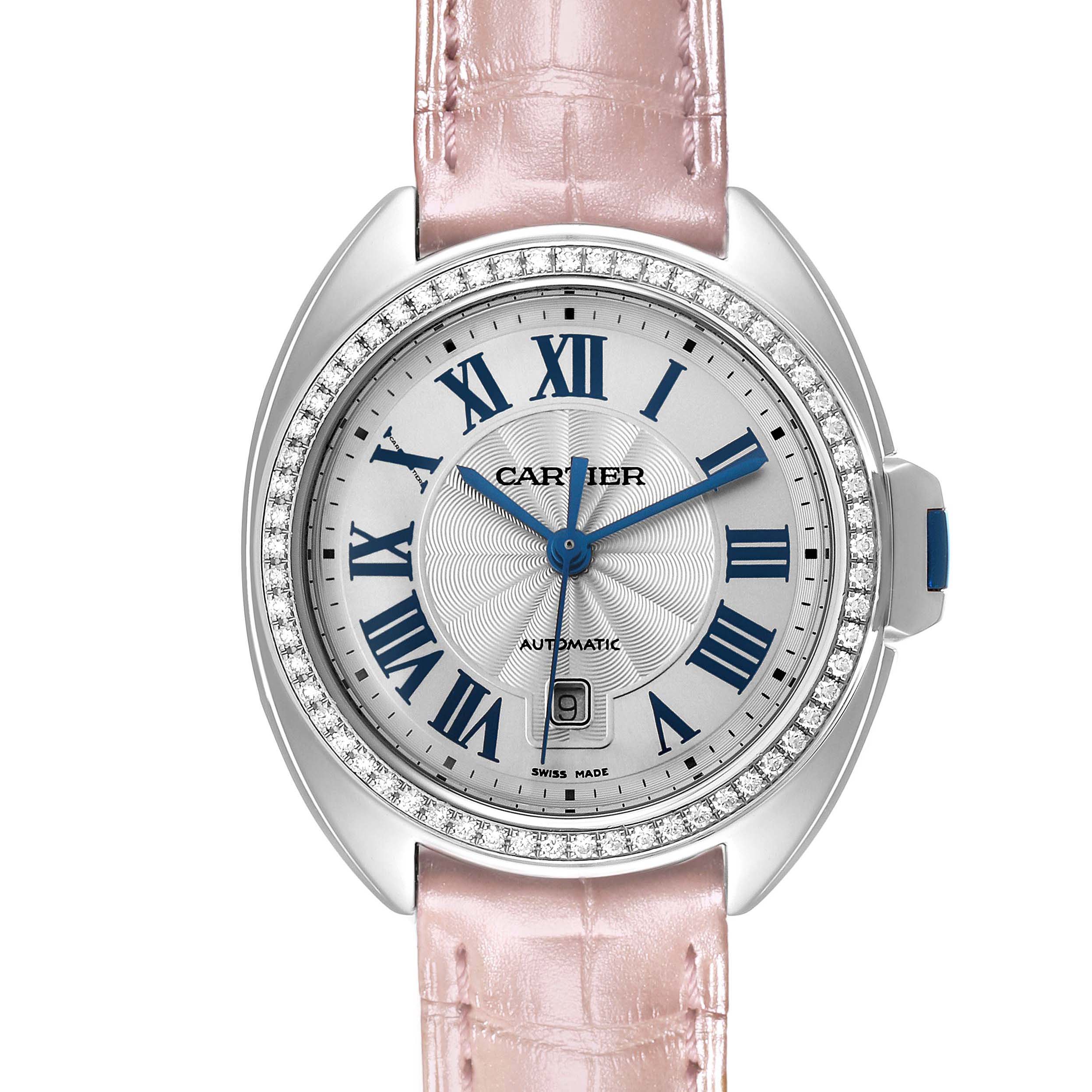 The Cartier Clé watch is shown from a front angle, displaying the dial, blue hands, Roman numerals, and pink strap.