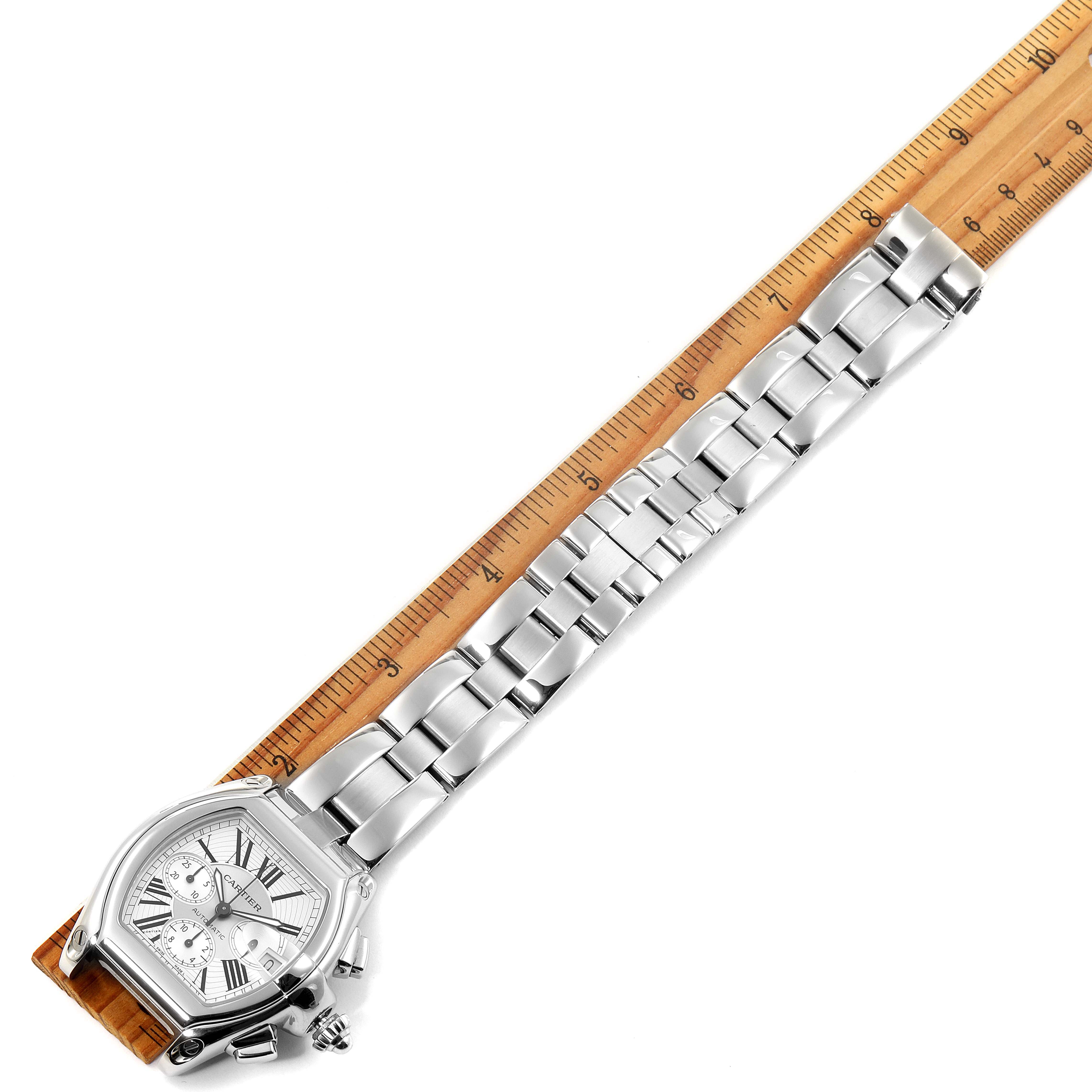 The image shows a Cartier Roadster W62019X6 Men's Stainless Steel Silver Dial W62019X6 Men's Stainless Steel Silver Dial watch placed alongside a ruler, displaying its entire length and metal bracelet.