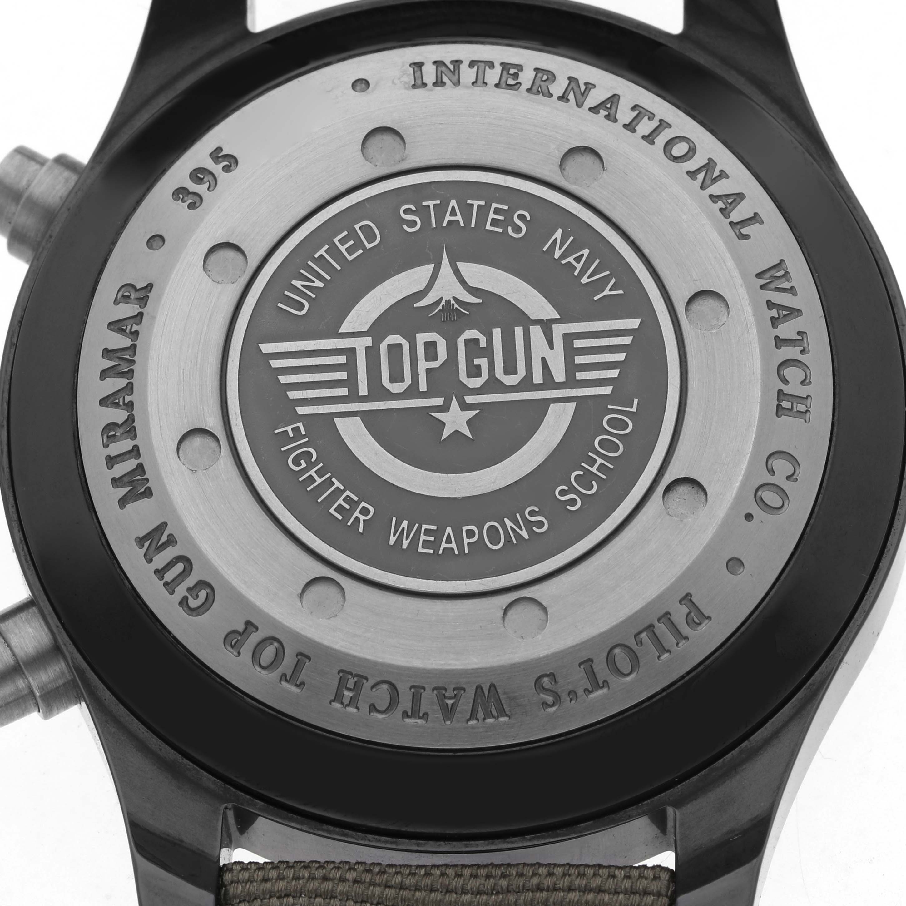 The image shows the back case of the IWC Pilot IW388002 Men's Ceramic Grey Dial model watch, featuring "Top Gun" and "United States Navy" engravings.
