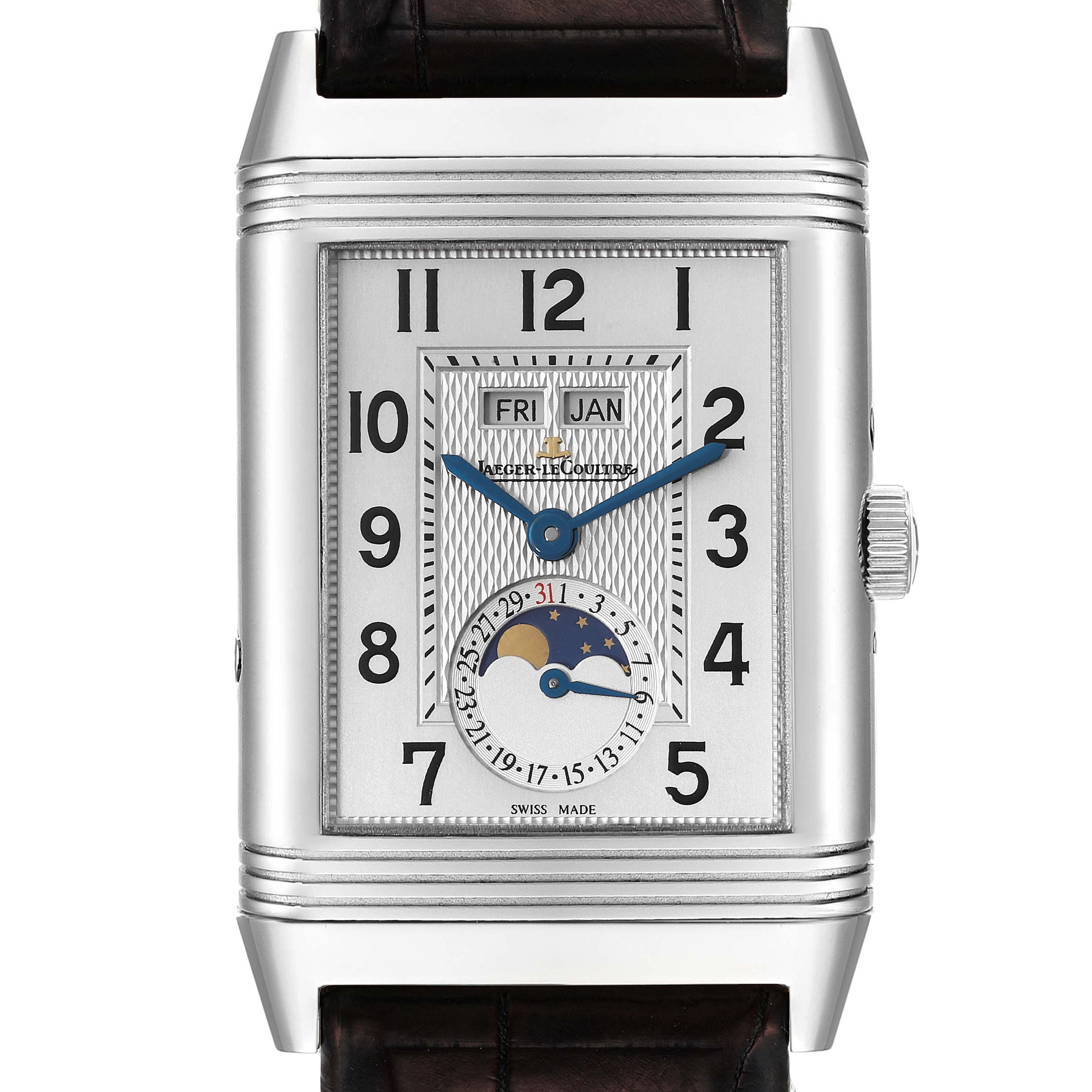 This Reverso model by Jaeger LeCoultre is shown from a frontal angle, displaying its rectangular dial, blue hands, day, date, and moon phase complications.