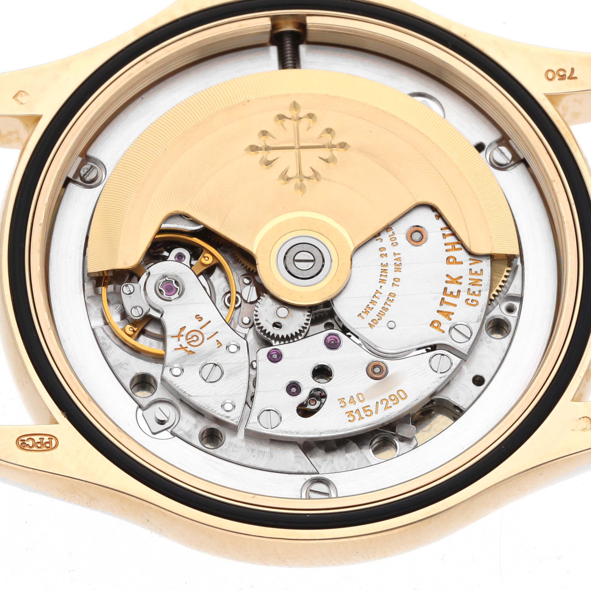 The image shows the movement of a Patek Philippe Calatrava 5107J Men's Yellow Gold Silver Dial watch viewed from the back, highlighting gears and decorative elements.