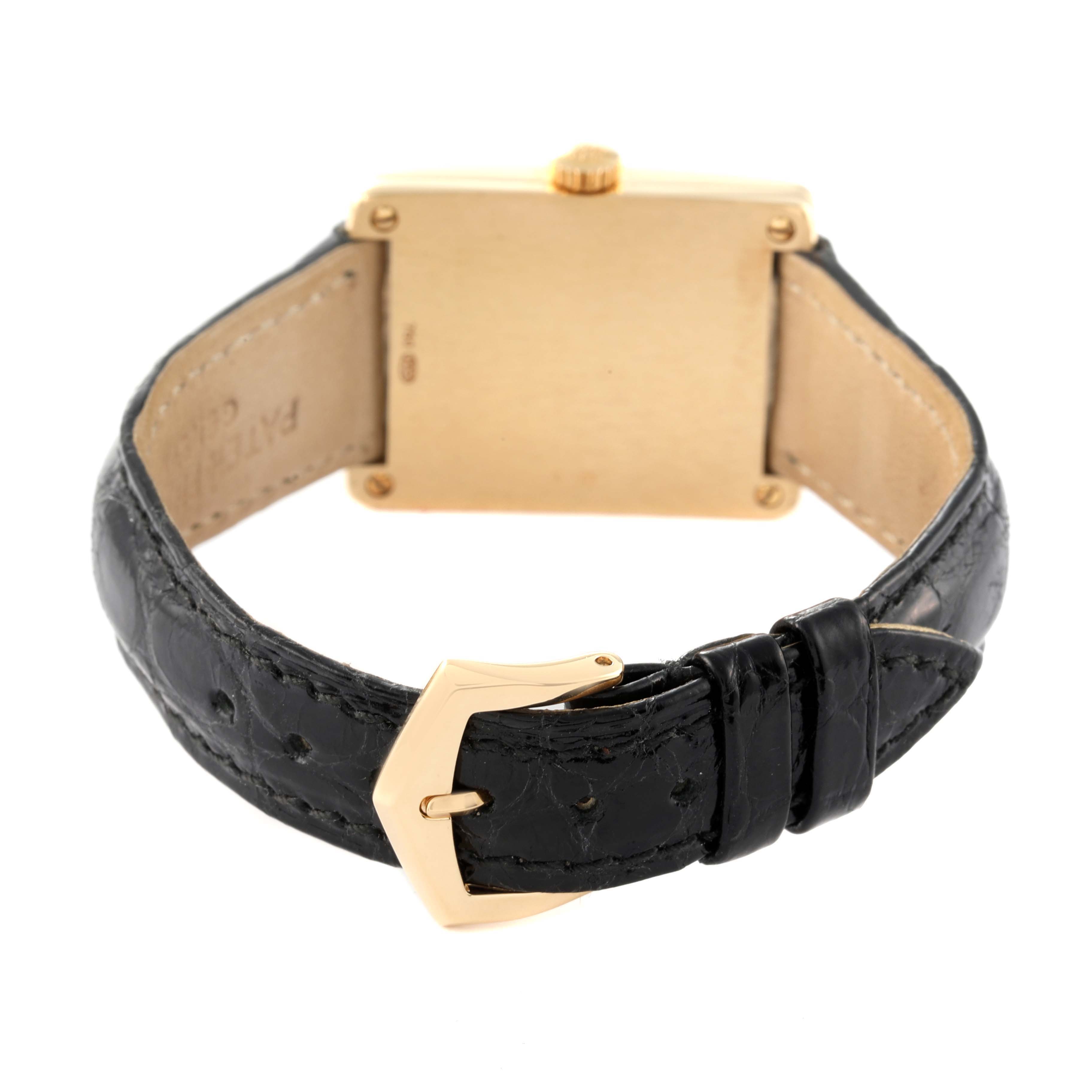 The image shows the back of a Patek Philippe Gondolo 5010J Men's Yellow Gold Silver Dial 5010J Men's Yellow Gold Silver Dial watch with a black leather strap and a gold buckle.