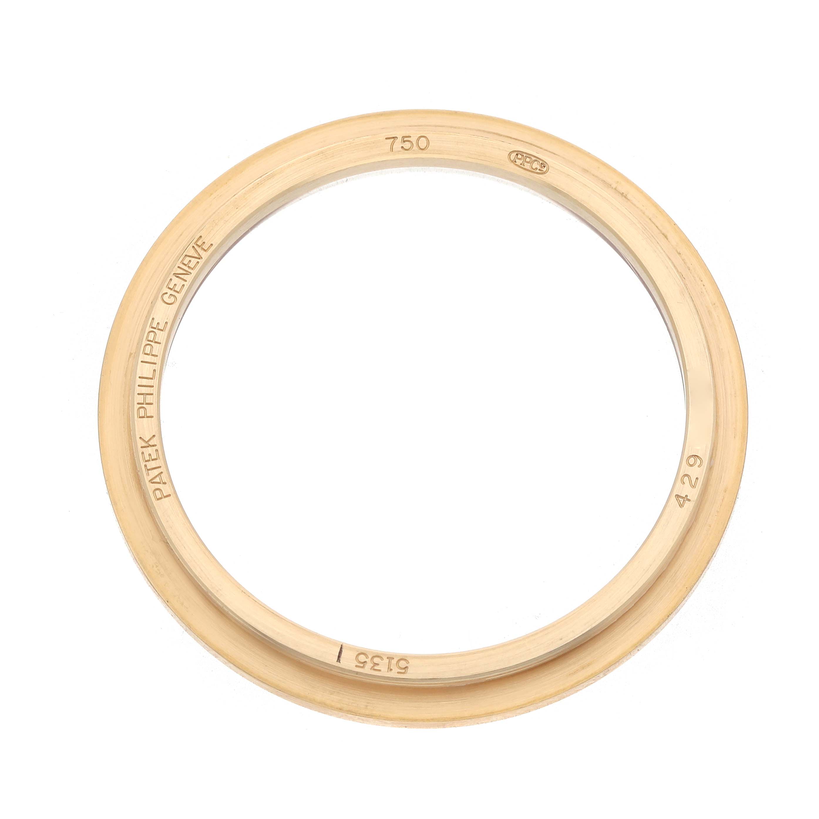 The image shows a gold bezel for a Patek Philippe Gondolo 5135J Men's Yellow Gold White Dial watch viewed from above, displaying brand engravings.
