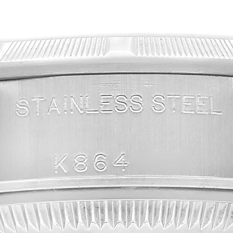 The image shows an angled view of the side of a Rolex Date 79190 Women
s Stainless Steel Pink Dial 79190 Women
s Stainless Steel Pink Dial model, highlighting "STAINLESS STEEL" and the serial number "K864".