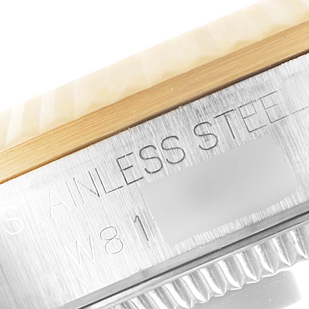 The image shows a close-up angle of the bezel and part of the case back of a Mid-Size Rolex watch, highlighting the "Stainless Steel" engraving.