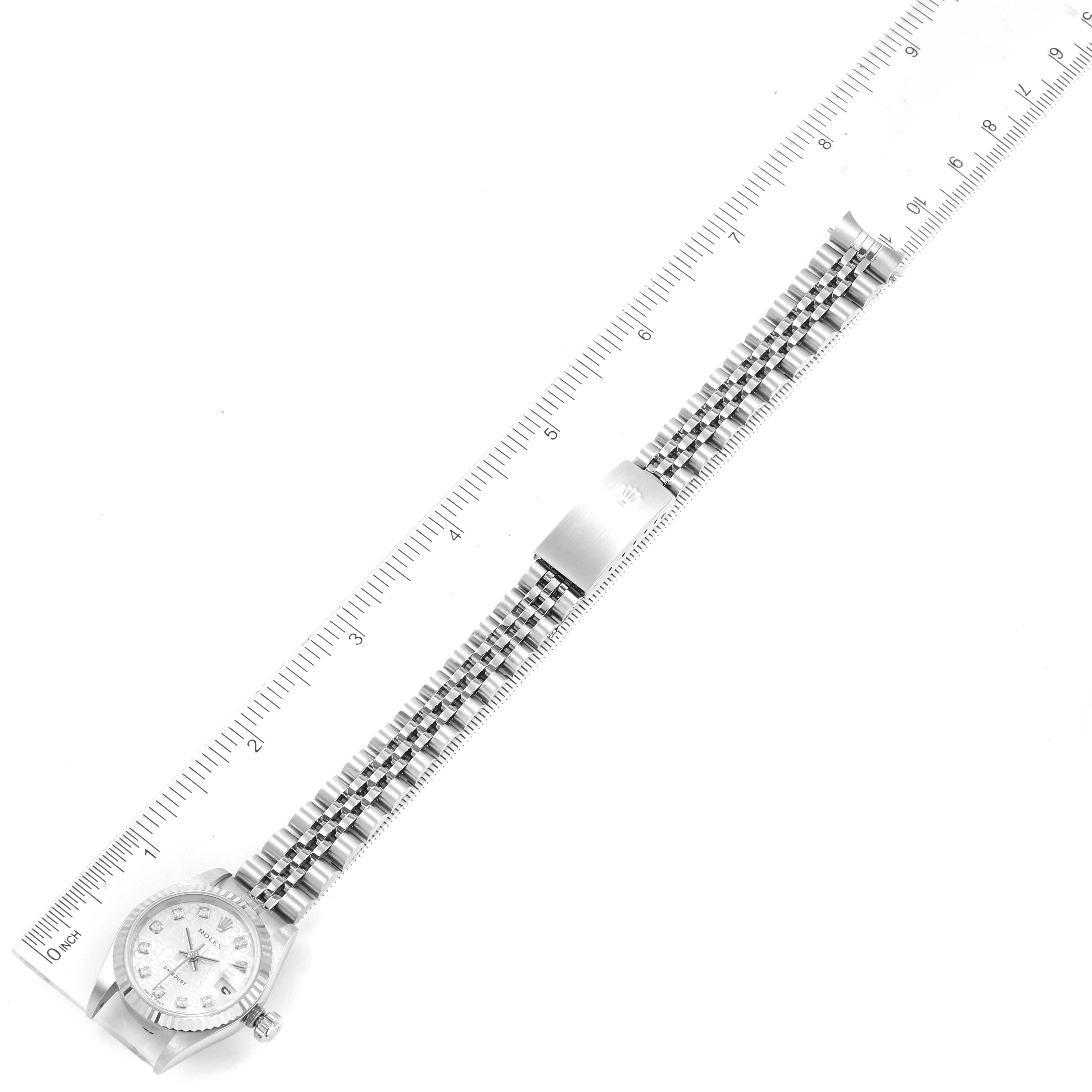 The Rolex Datejust 79174 Women
s Stainless Steel Silver Dial 79174 Women
s Stainless Steel Silver Dial watch is shown from a top-down angle, displaying the entire bracelet and case, alongside a millimeter ruler.