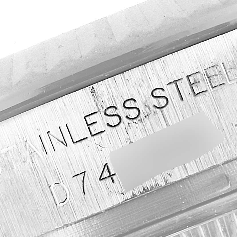 This image shows a close-up of the engraved side of a Rolex Datejust 179174 Women
s Stainless Steel Mother of Pearl Dial 179174 Women
s Stainless Steel Mother of Pearl Dial watch featuring the text "STAINLESS STEEL."