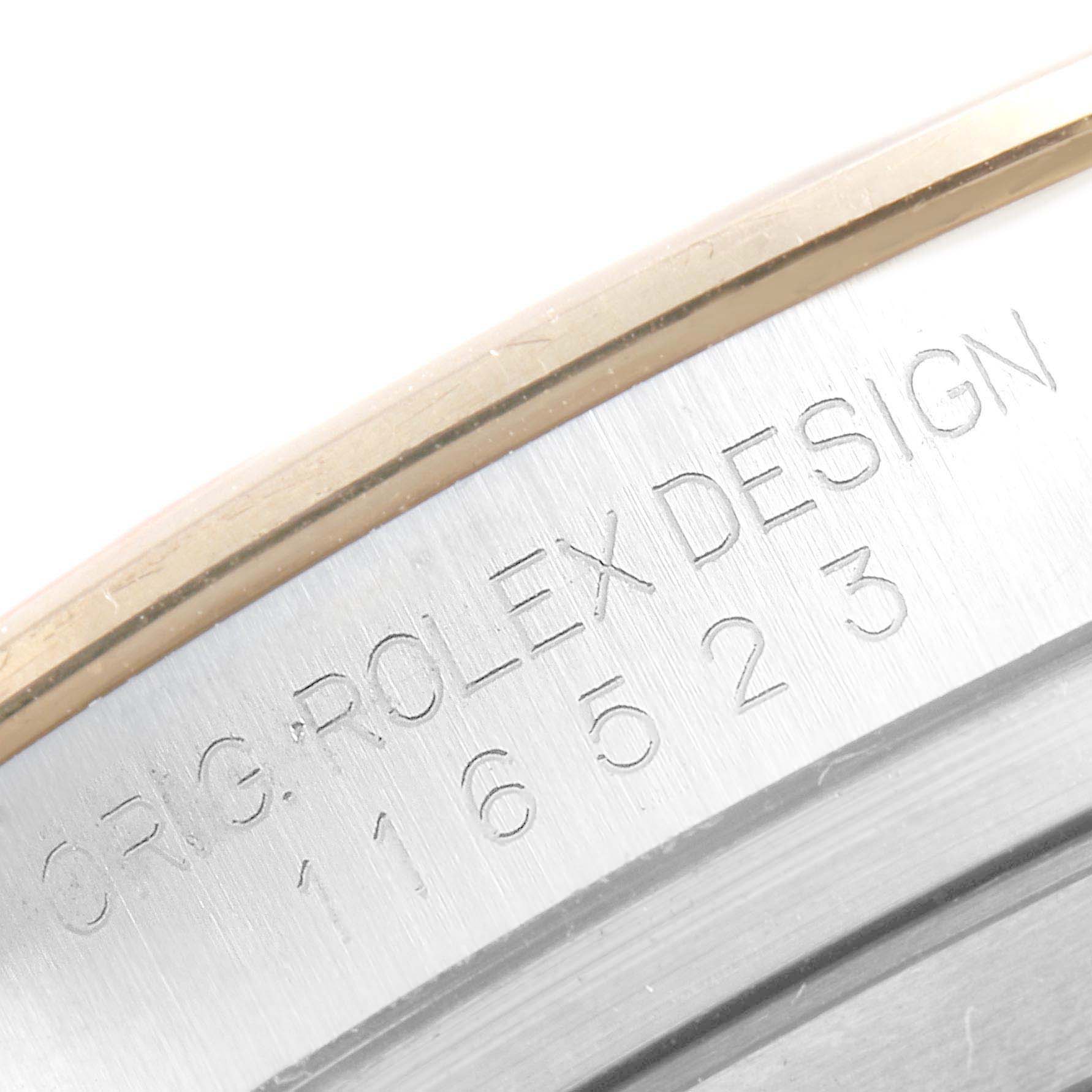 This close-up image shows a part of the case with engraved text for the Rolex Daytona 116523 Men's Steel and Gold (two tone) Champagne Dial 116523 Men's Steel and Gold (two tone) Champagne Dial model.