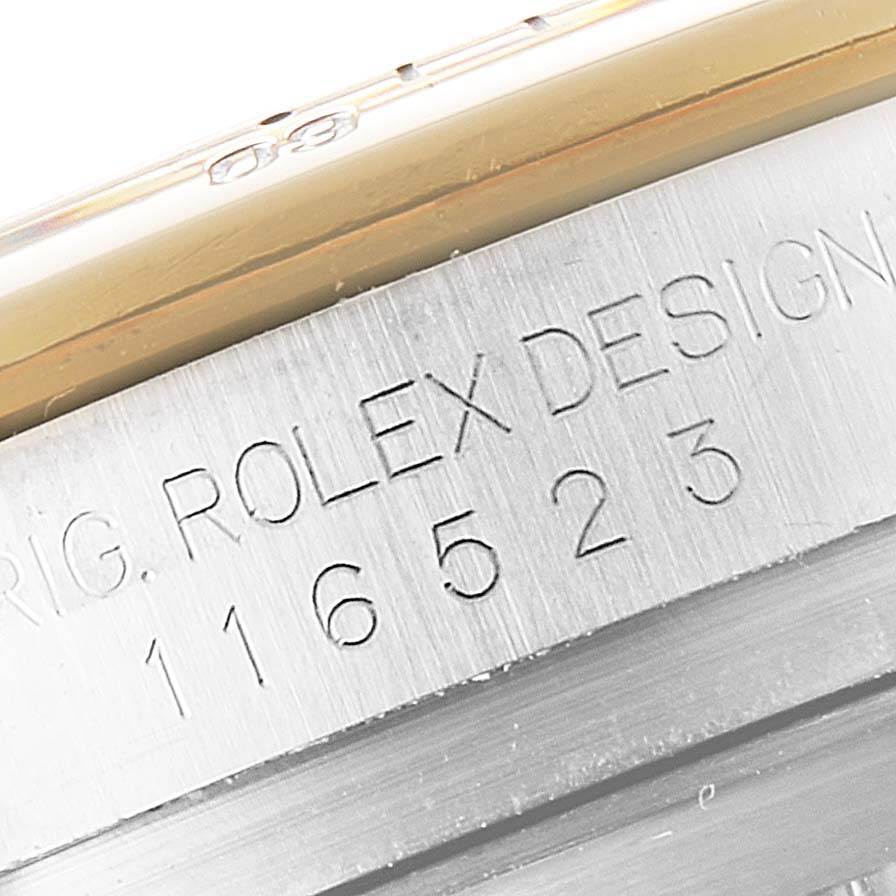 The image shows a close-up of the side engraving on a Rolex Daytona 116523 Men
s Steel and Gold (two tone) Black Dial 116523 Men
s Steel and Gold (two tone) Black Dial watch, displaying "ROLEX DESIGN" and the model number "116523".