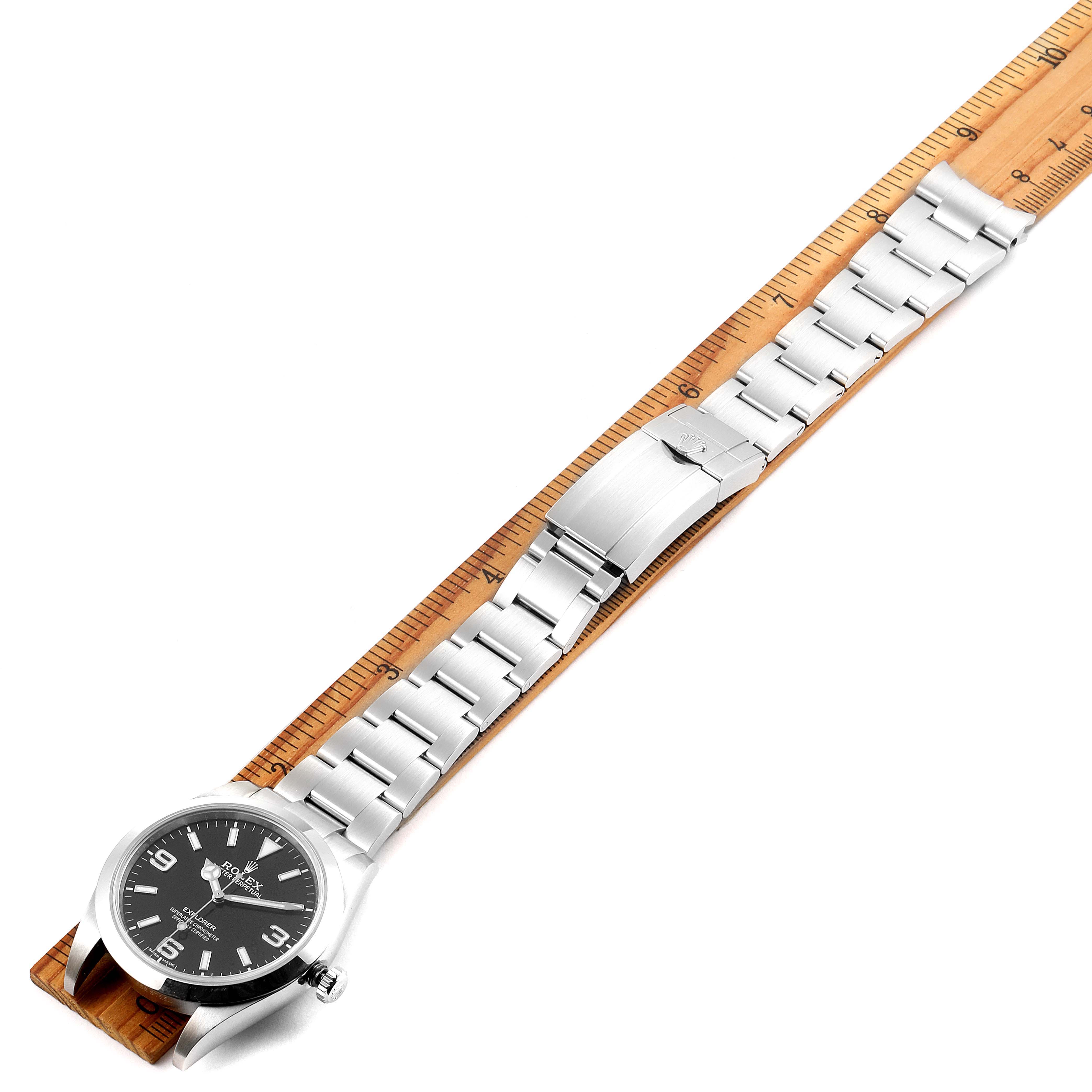 The image shows a side angle of a Rolex Explorer 214270 Men
s Stainless Steel Black Dial 214270 Men
s Stainless Steel Black Dial watch displaying its face, stainless steel bracelet, and clasp.