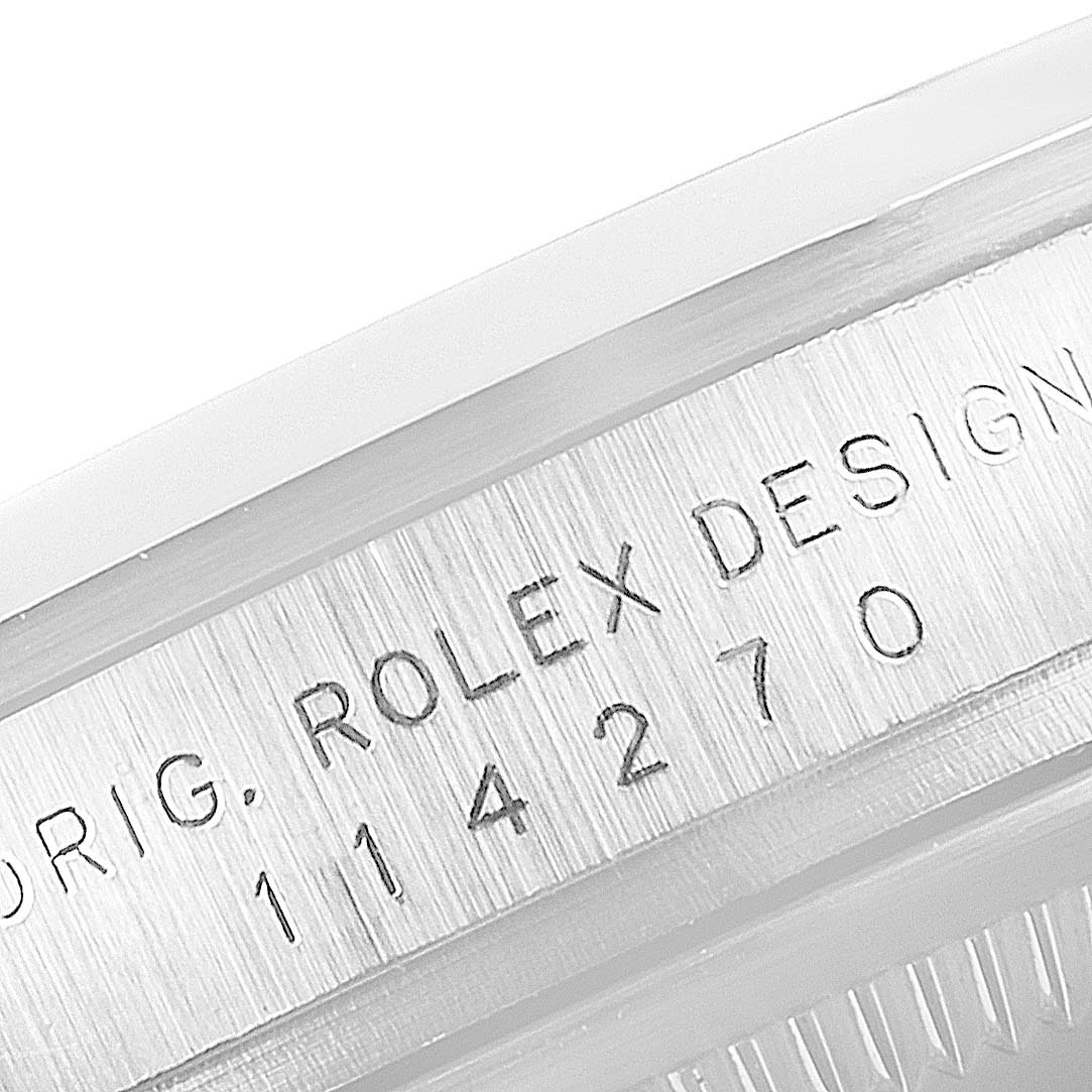 This close-up image shows the engraved serial number and "ROLEX DESIGN" on the side of a Rolex Explorer 114270 Men
s Stainless Steel Black Dial 114270 Men
s Stainless Steel Black Dial watch case.