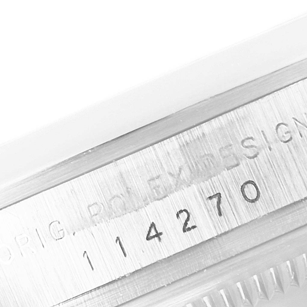 The image shows a close-up of the serial number and part of the bezel from the Rolex Explorer 114270 Men's Stainless Steel Black Dial 114270 Men's Stainless Steel Black Dial watch.