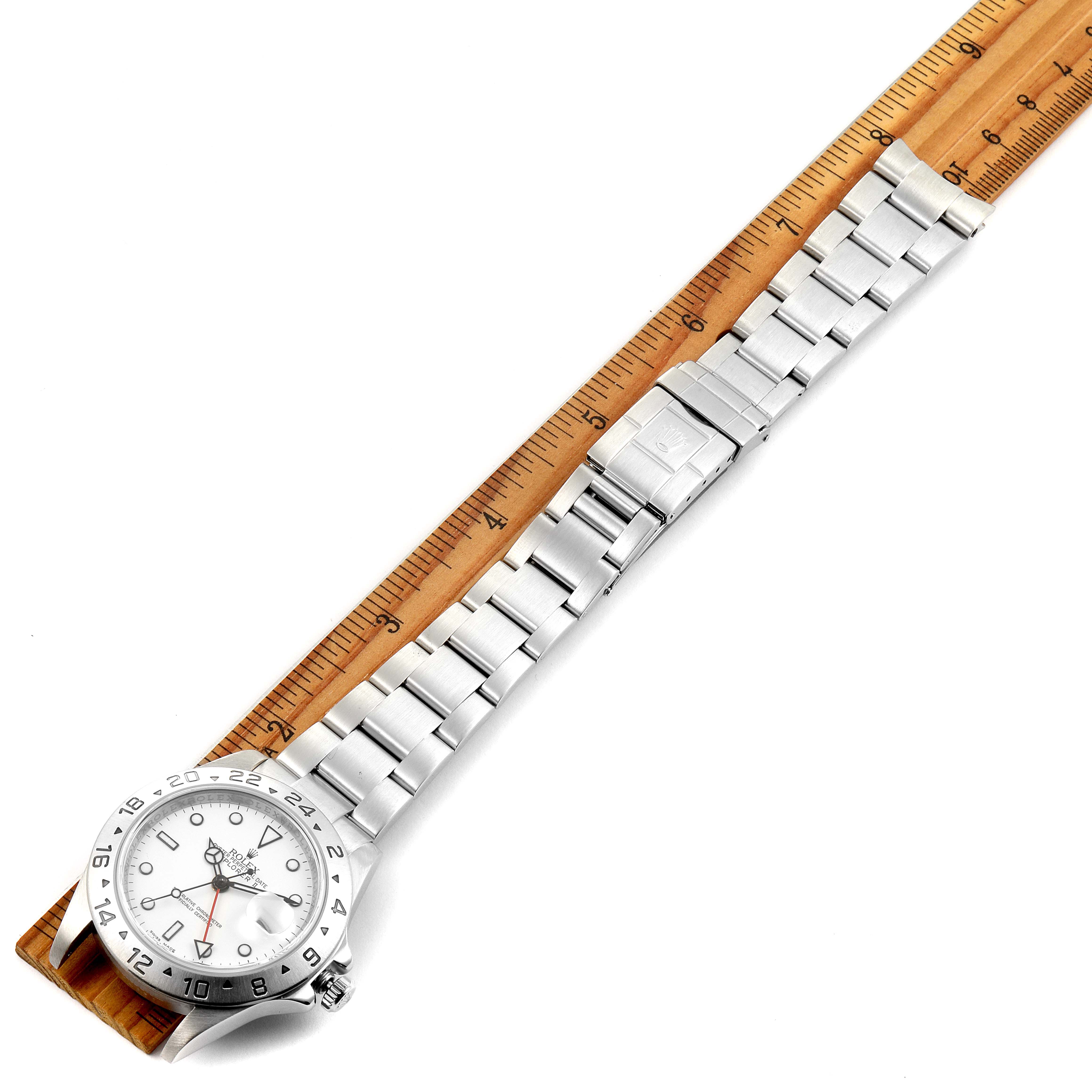 This image shows the complete Rolex Explorer 16570 Men
s Stainless Steel White Dial 16570 Men
s Stainless Steel White Dial watch, including its dial and bracelet, horizontally aligned next to a ruler.