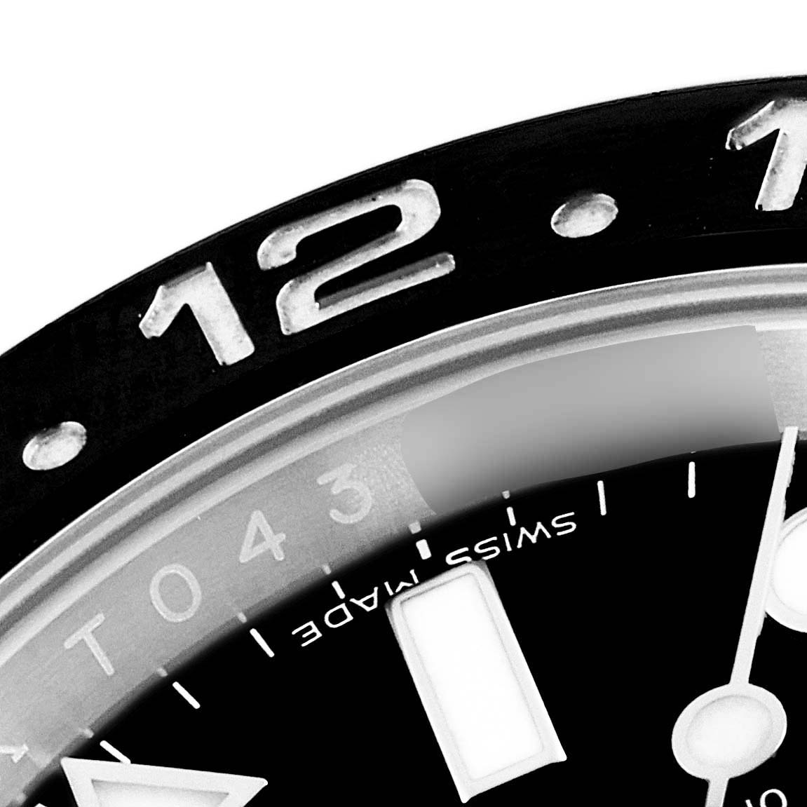 This image shows a close-up of the bezel and part of the dial of a Rolex GMT-Master 116710 Men
s Stainless Steel Black Dial 116710 Men
s Stainless Steel Black Dial watch, highlighting the "12" marker.