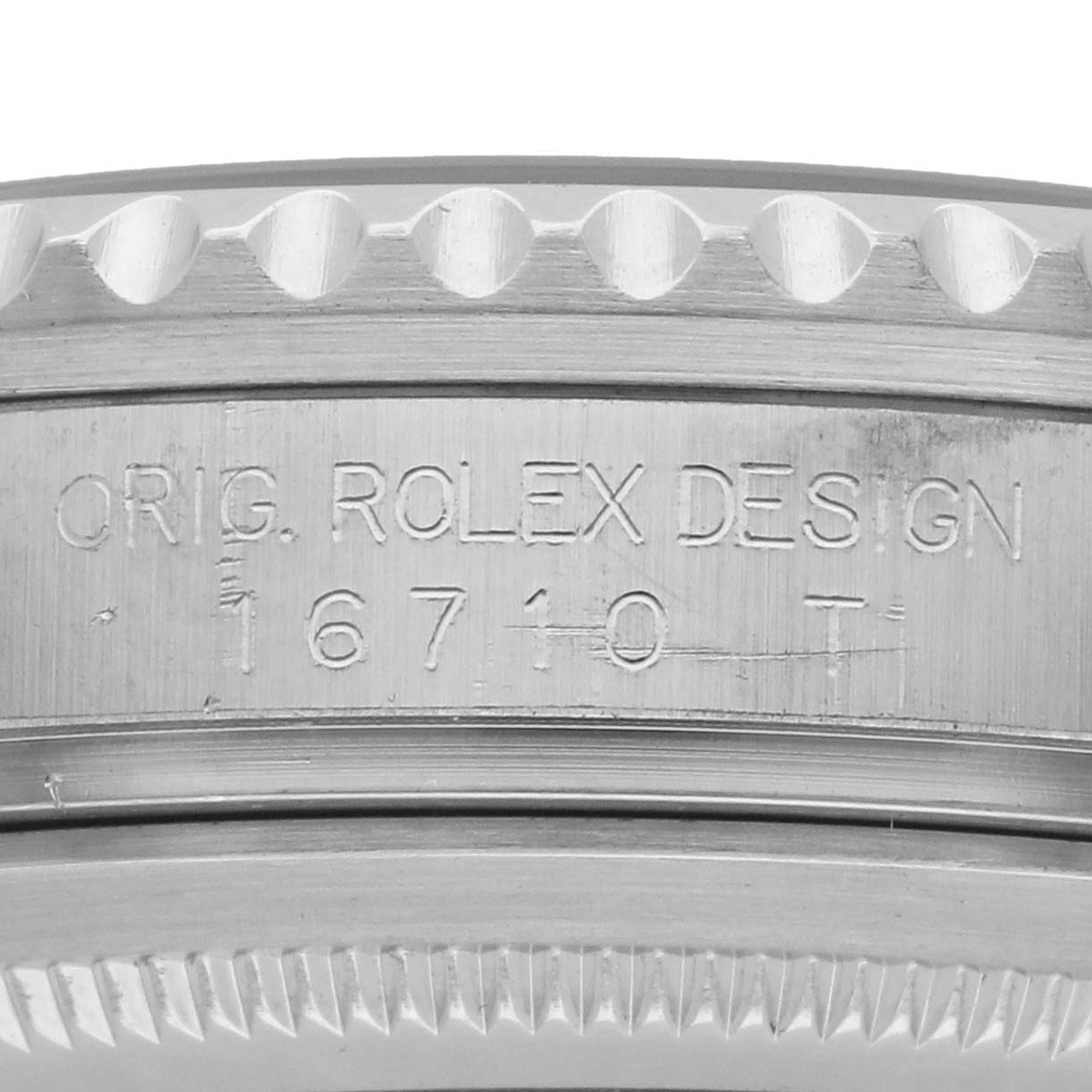 The image shows the side engraving of a Rolex GMT-Master 16710 Men's Stainless Steel Black Dial model 16710, focusing on the case and bezel edge.