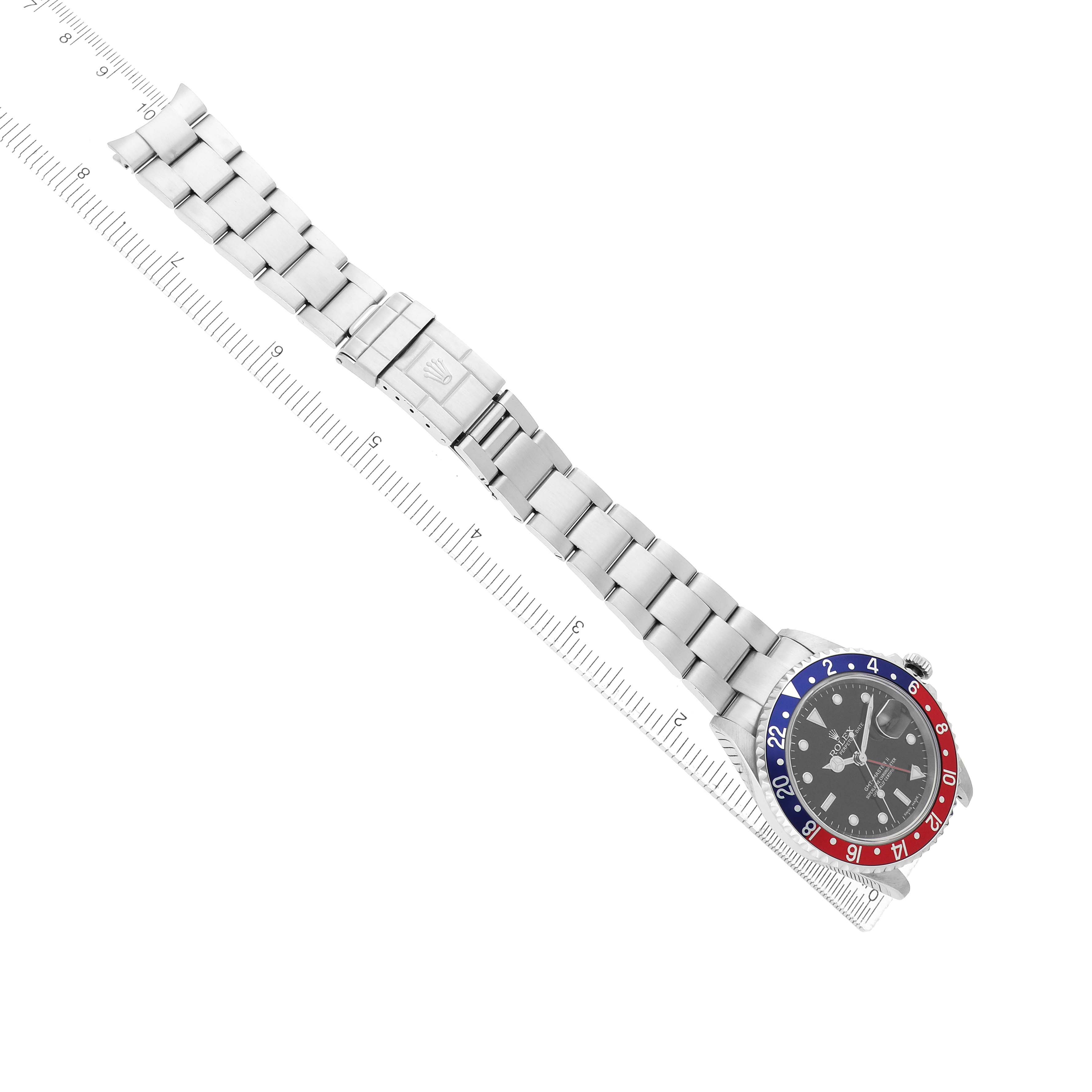 The Rolex GMT-Master 16710 Men's Stainless Steel Black Dial watch is shown from a top view, displaying the full bracelet, clasp, and bezel with a ruler for scale.