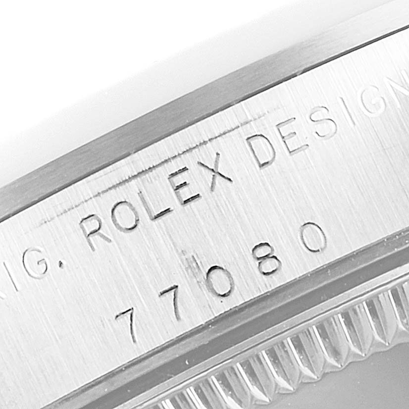 This image shows an engraved case side of a Mid-Size Rolex watch, including the model number 77080.