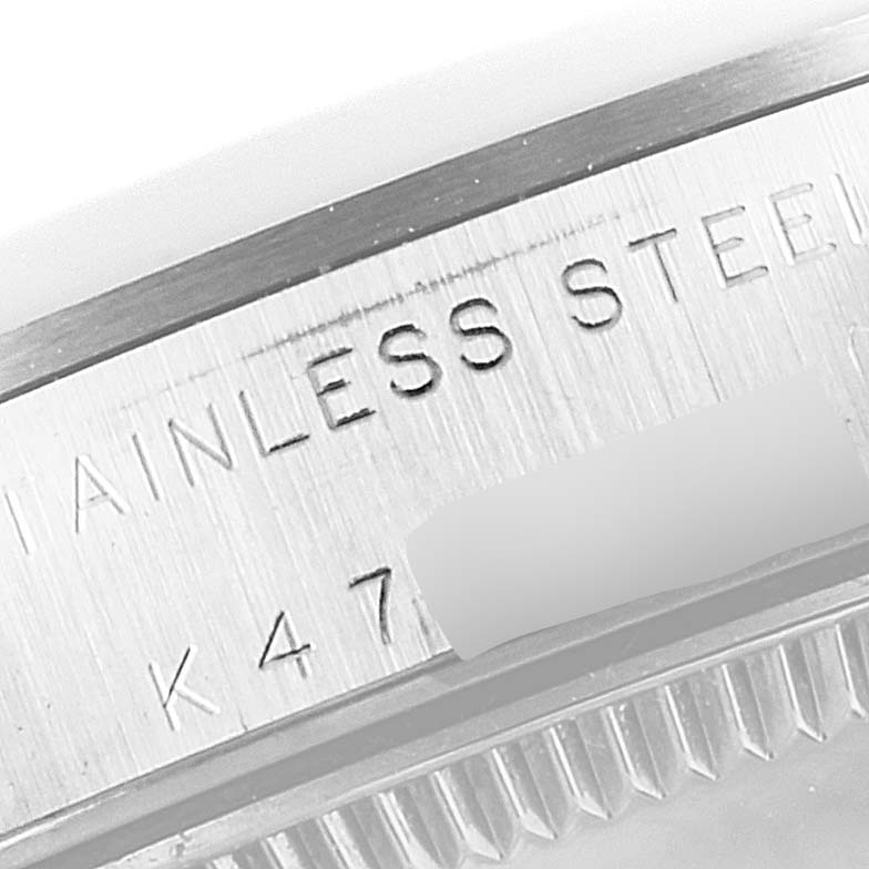 This close-up image shows the serial number and "STAINLESS STEEL" engraving on a Mid-Size Rolex watch case.