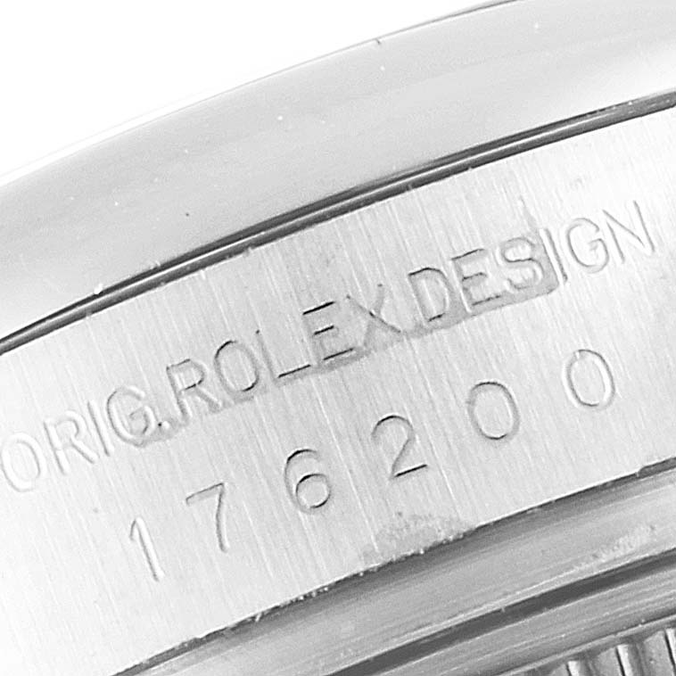 The image shows a close-up of the case back edge of a Rolex Oyster Perpetual 176200 Women's Stainless Steel Silver Dial 176200 Women's Stainless Steel Silver Dial with its model number and "ROLEX DESIGN" engraved.