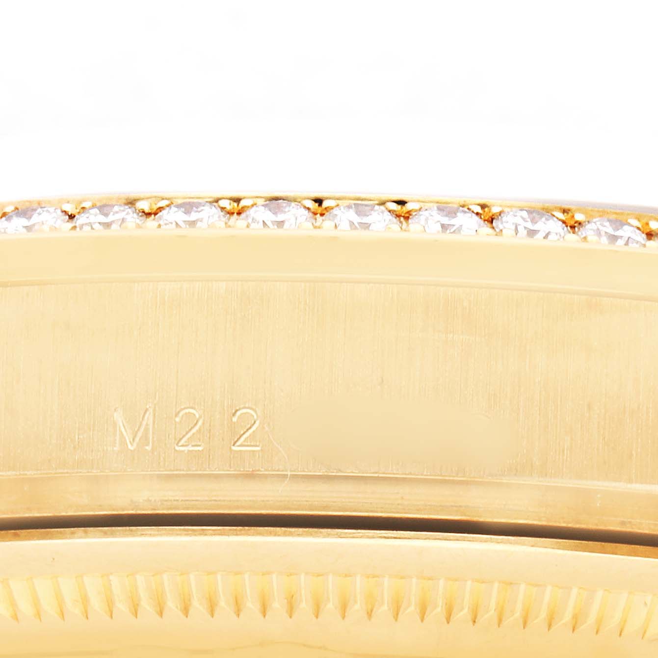 The image shows a close-up of the Rolex President 118388 Men's Yellow Gold Green Dial model's gold bezel with diamonds and part of the case side.