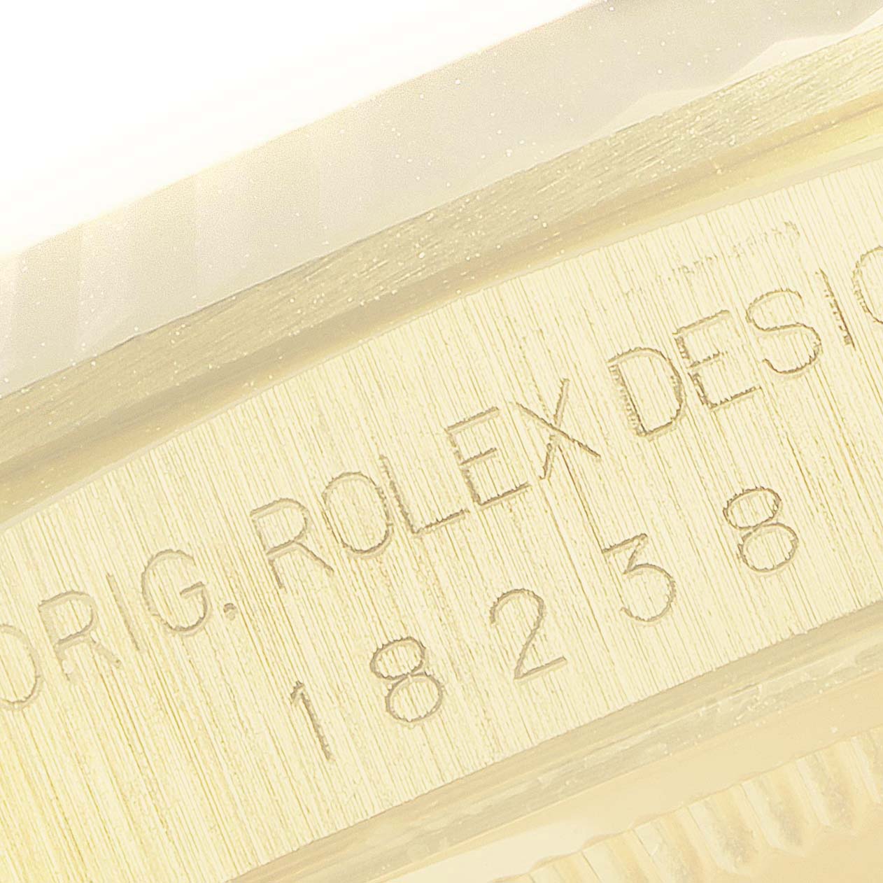 The image shows an angled close-up of the Rolex President 18238 Men
s Yellow Gold Champagne Dial 18238 Men
s Yellow Gold Champagne Dial model
s engraved case with reference number 18238.
