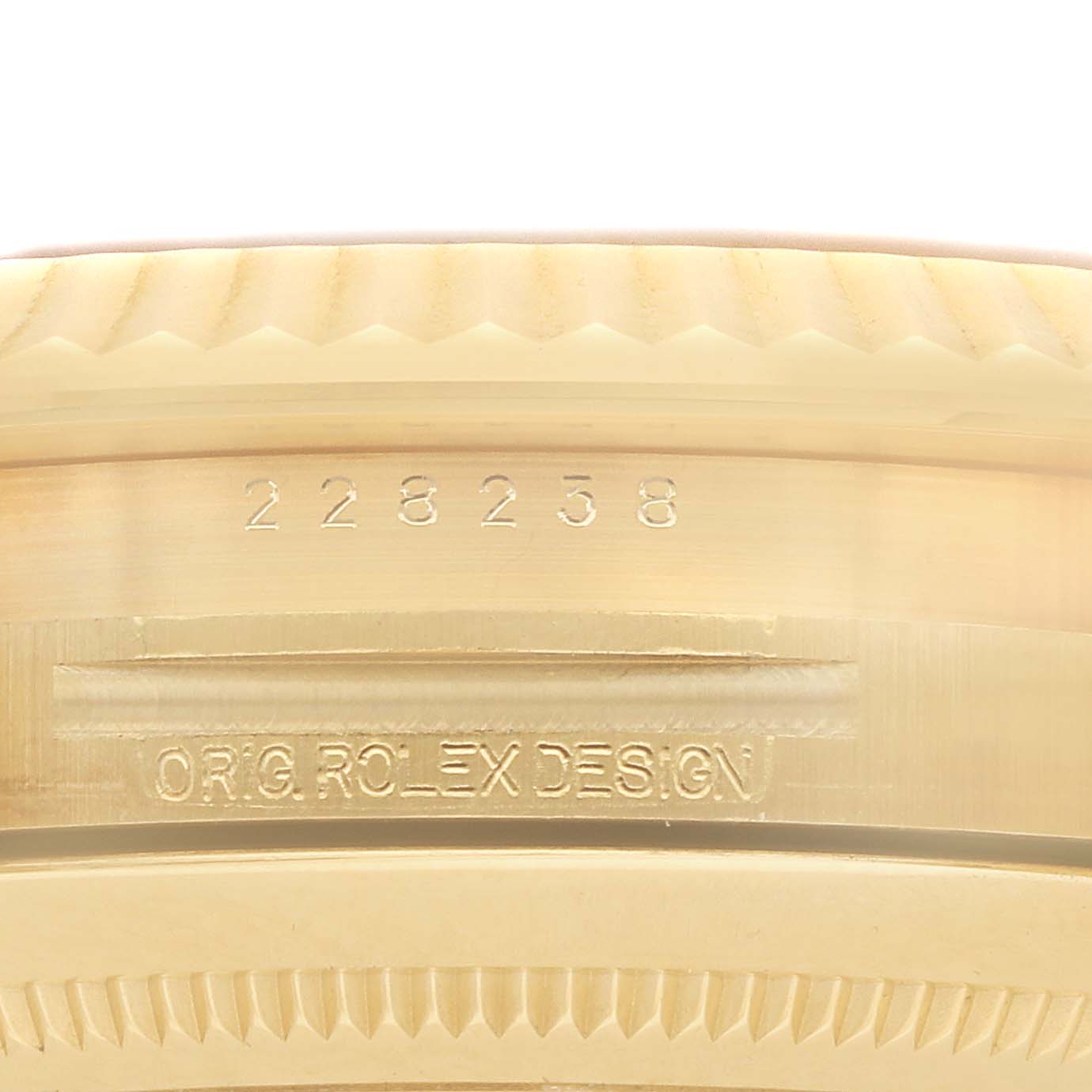 The image shows a close-up of the bezel and outer case edge of a Rolex President 228238 Men's Yellow Gold Champagne Dial watch, displaying a model number and design engraving.