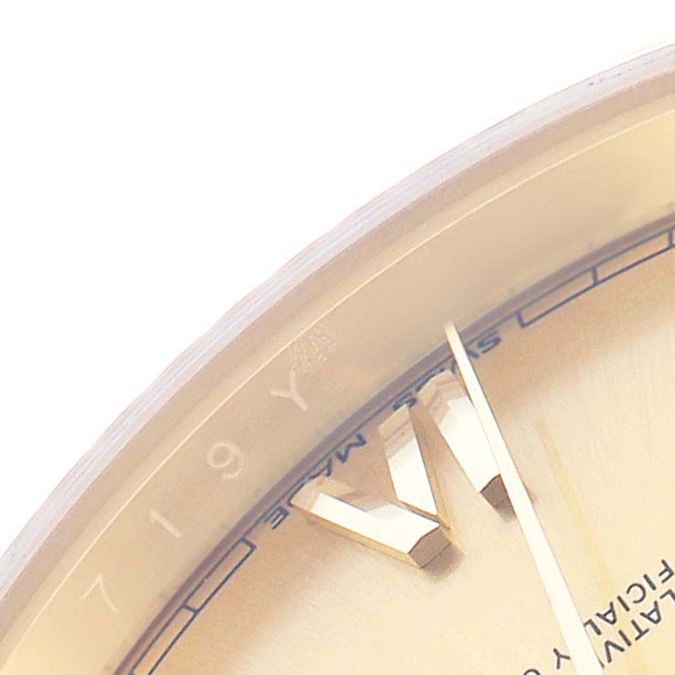 The image shows a close-up of the Rolex President 228238 Men's Yellow Gold Champagne Dial watch face, featuring part of the dial, gold hour markers, and a partial view of the bezel.