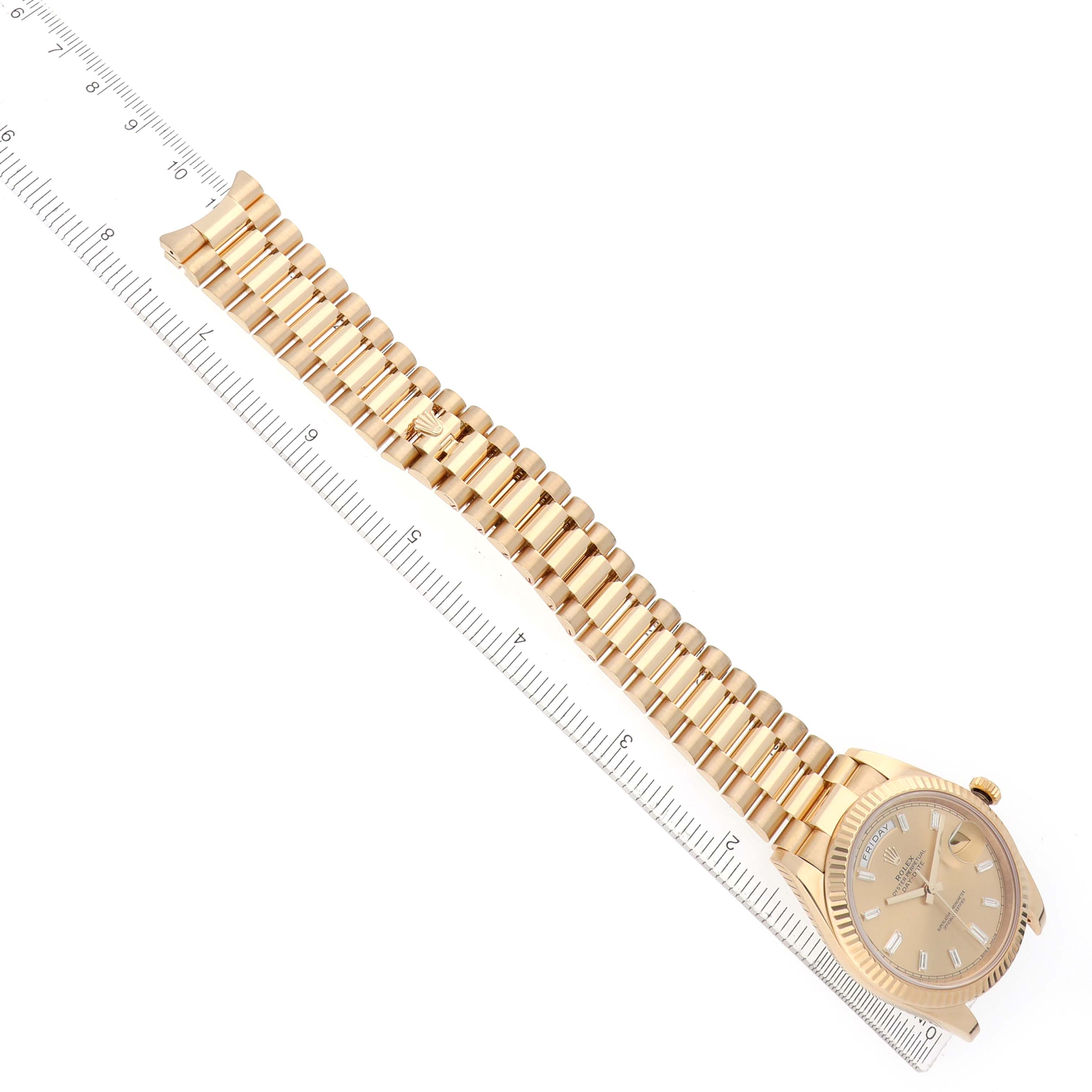 The Rolex President 228238 Men's Yellow Gold Champagne Dial watch is shown at a top-down angle, with the face and entire bracelet visible, next to a ruler for scale.