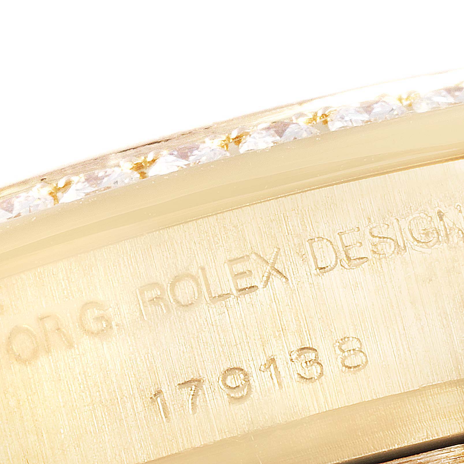 This image shows a close-up of the side engraving and bejeweled bezel of a Rolex President 179138 Women's Yellow Gold Mother of Pearl Dial 179138 Women's Yellow Gold Mother of Pearl Dial watch.