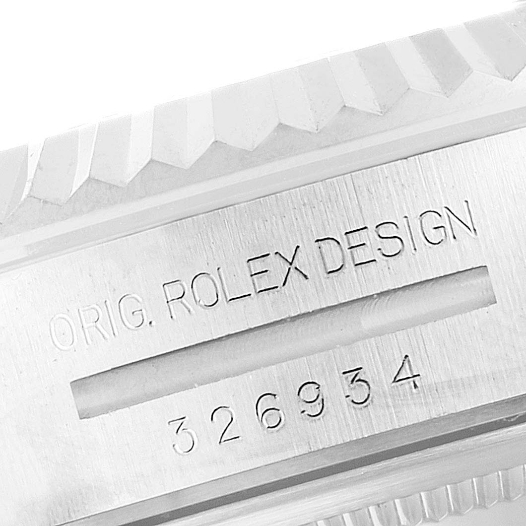 The image shows the engraved side of a Rolex Sky-Dweller 326934 Men's Stainless Steel White Dial 326934 Men's Stainless Steel White Dial watch case with "ORIG. ROLEX DESIGN" and numeric markings.
