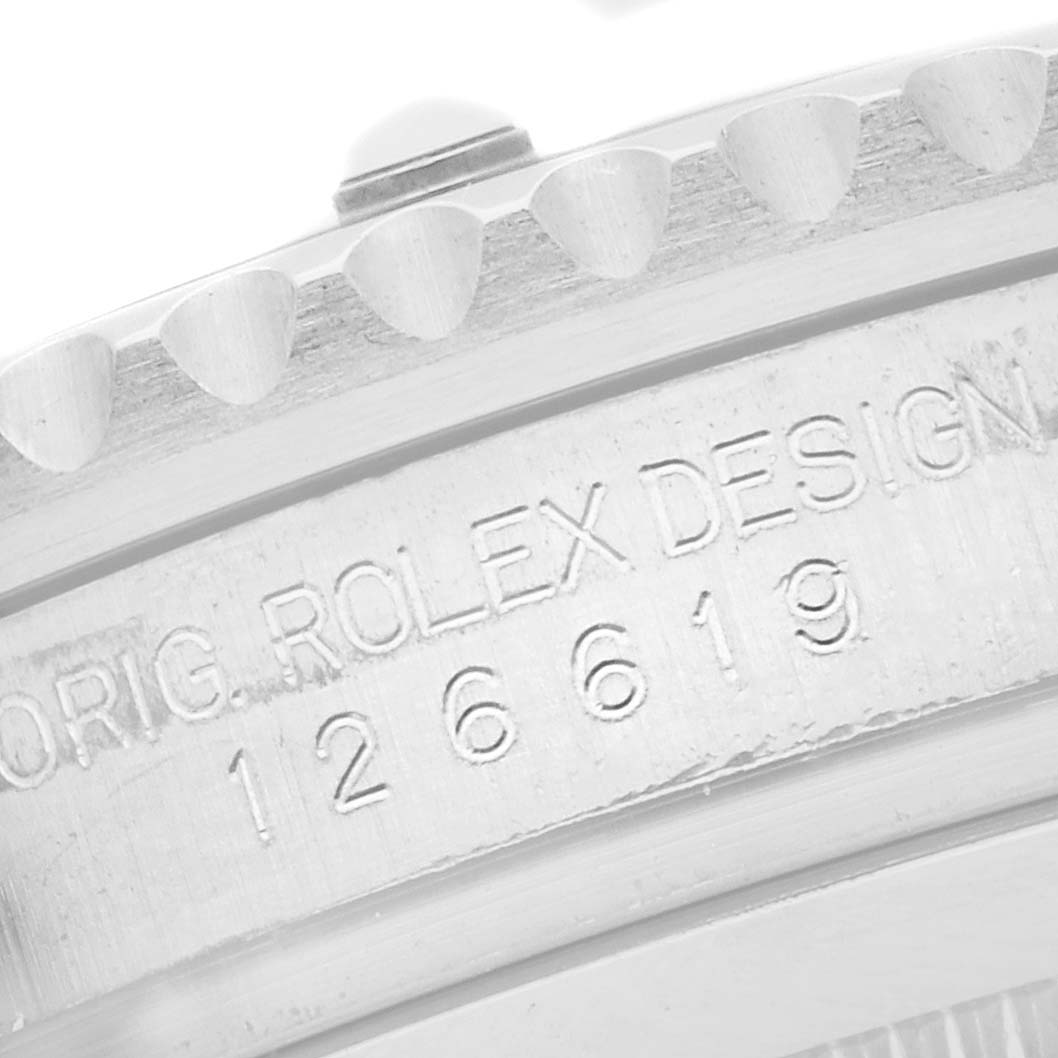 The image shows a close-up of the bezel and engraved edge on a Rolex Submariner 126619 Men's White Gold Black Dial watch.