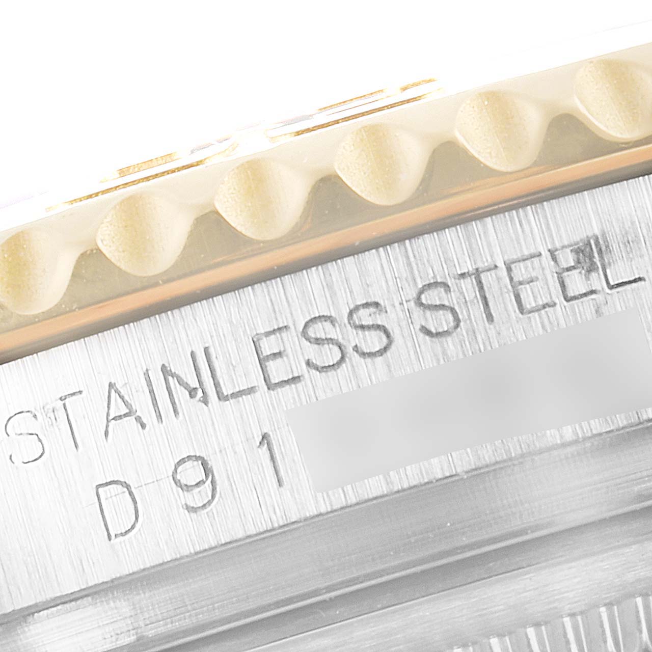 The image shows the side engraving of a Rolex Yacht-Master 16623 Men's Stainless Steel Champagne Dial 16623 Men's Stainless Steel Champagne Dial watch, focusing on the text "STAINLESS STEEL" and the serial number.