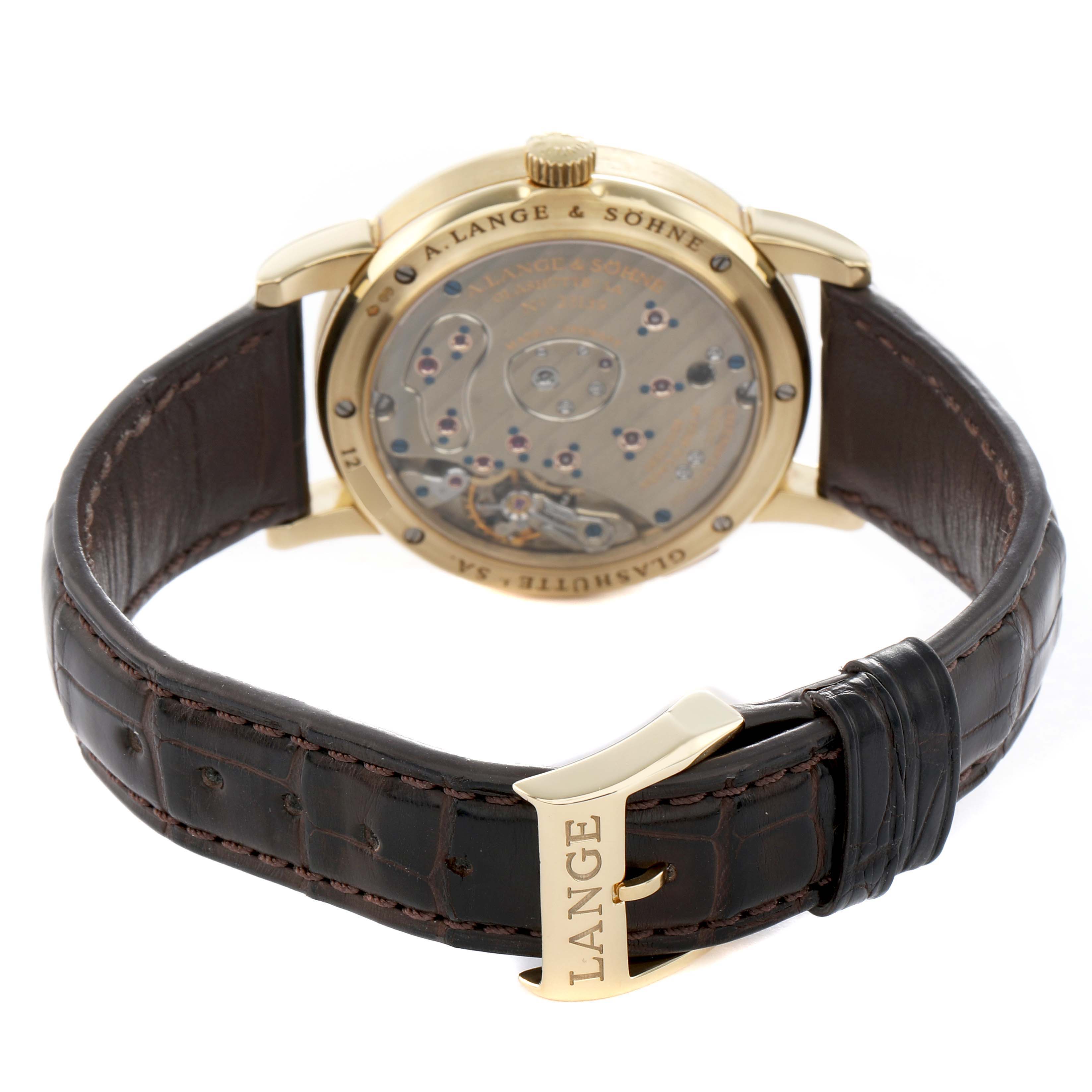 The image shows the back of the A. Lange & Sohne Lange 1 101.021 Men's Yellow Gold Silver Dial watch, displaying the movement and leather strap from a rear angle.