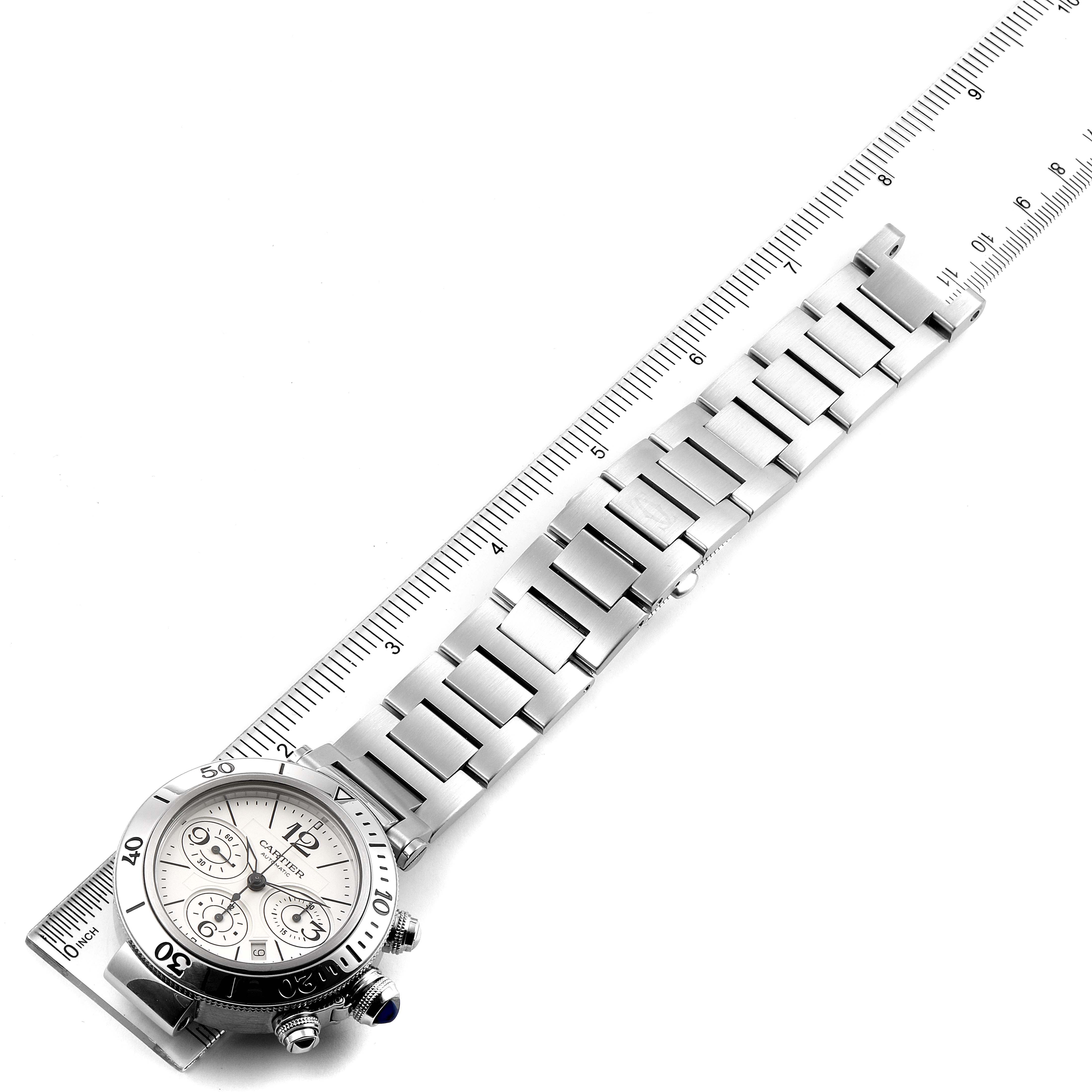 The Cartier Pasha W31089M7 Men's Stainless Steel Silver Dial W31089M7 Men's Stainless Steel Silver Dial watch is shown from an overhead angle, featuring its stainless steel band and watch face next to a ruler for scale.