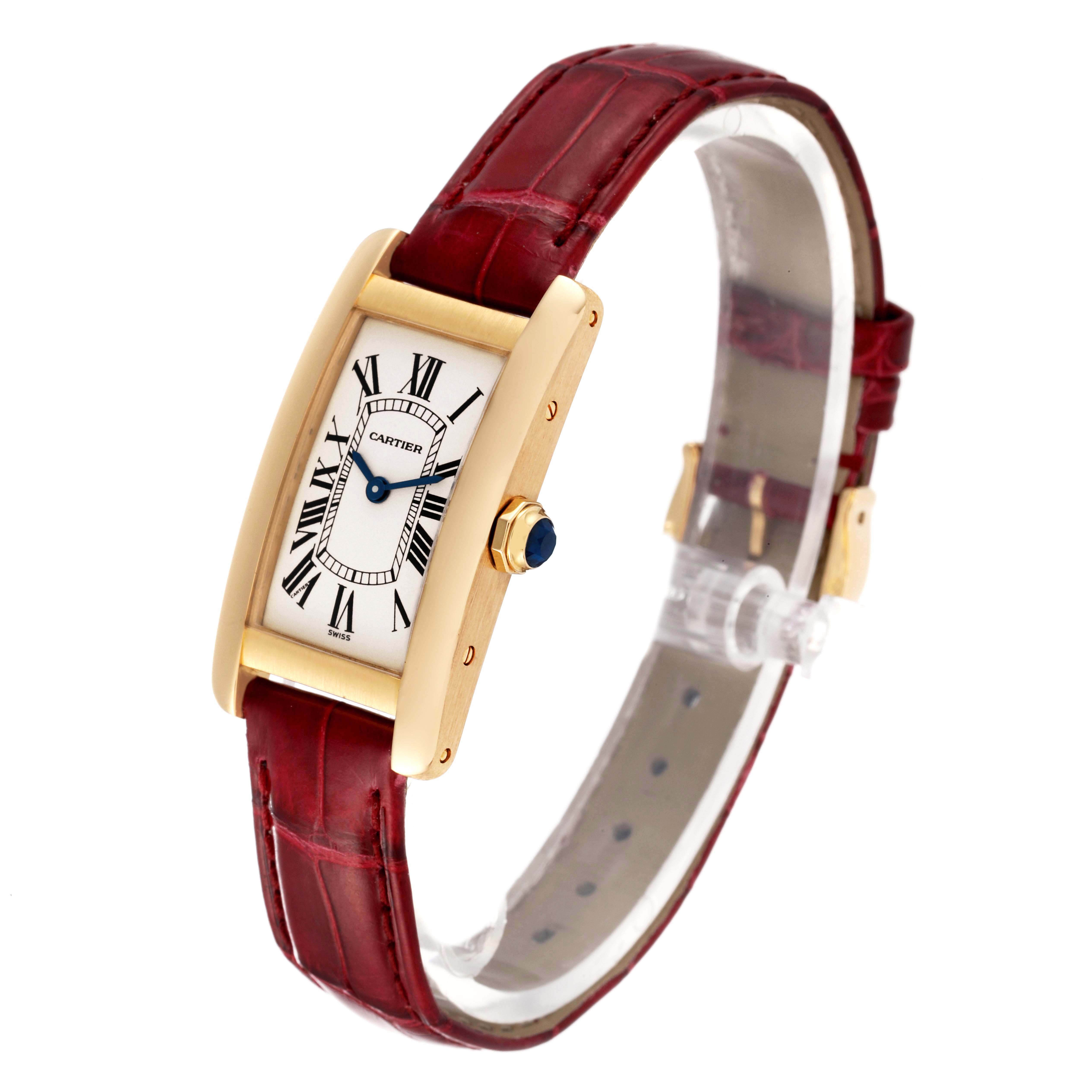 The image shows a Cartier Tank Americaine W2601556 Women
s Yellow Gold Silver Dial W2601556 Women
s Yellow Gold Silver Dial watch at a side angle, displaying its red strap, gold case, and Roman numeral dial.