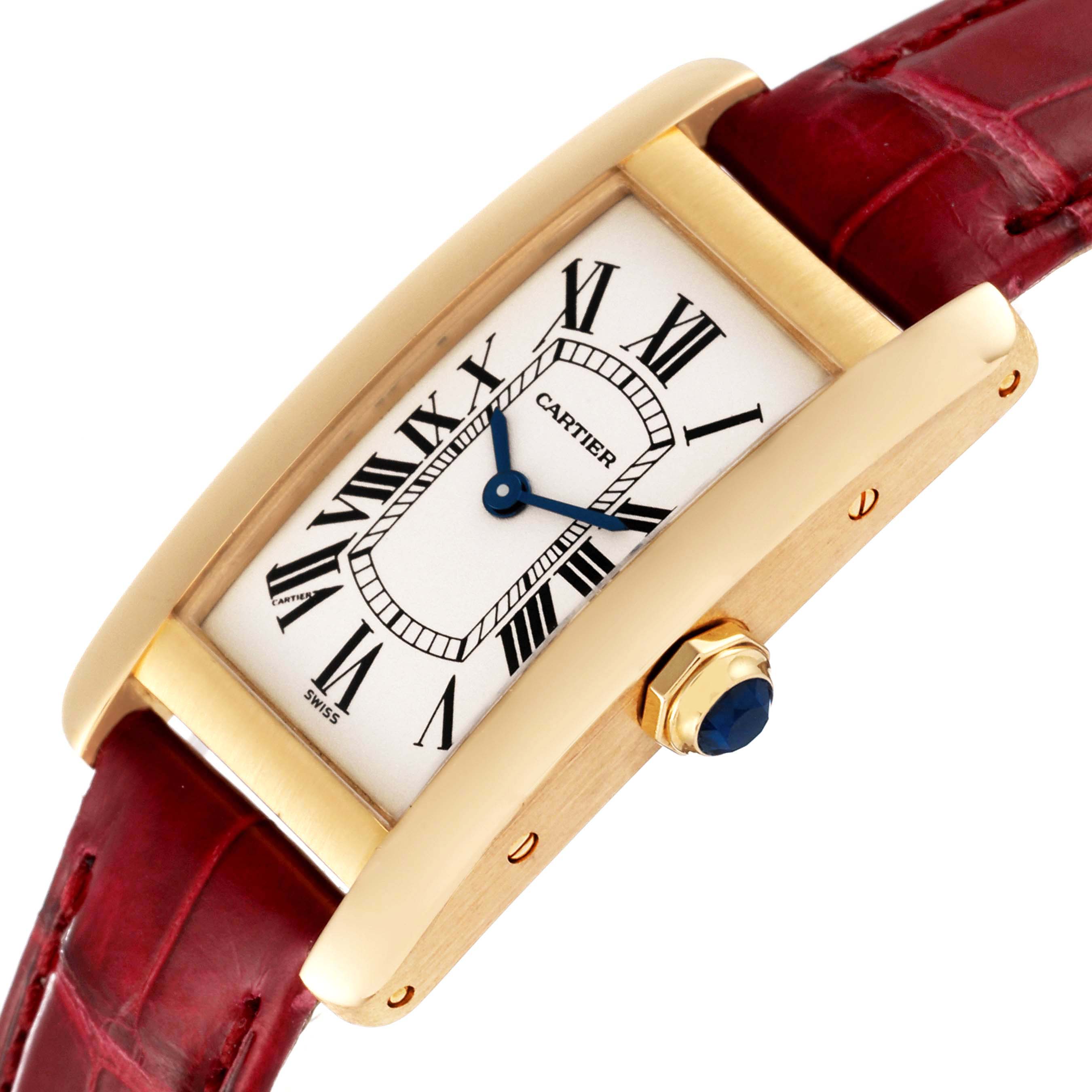 This image shows a Cartier Tank Americaine W2601556 Women
s Yellow Gold Silver Dial W2601556 Women
s Yellow Gold Silver Dial watch angled slightly from the side, displaying its dial, crown, and red leather strap.
