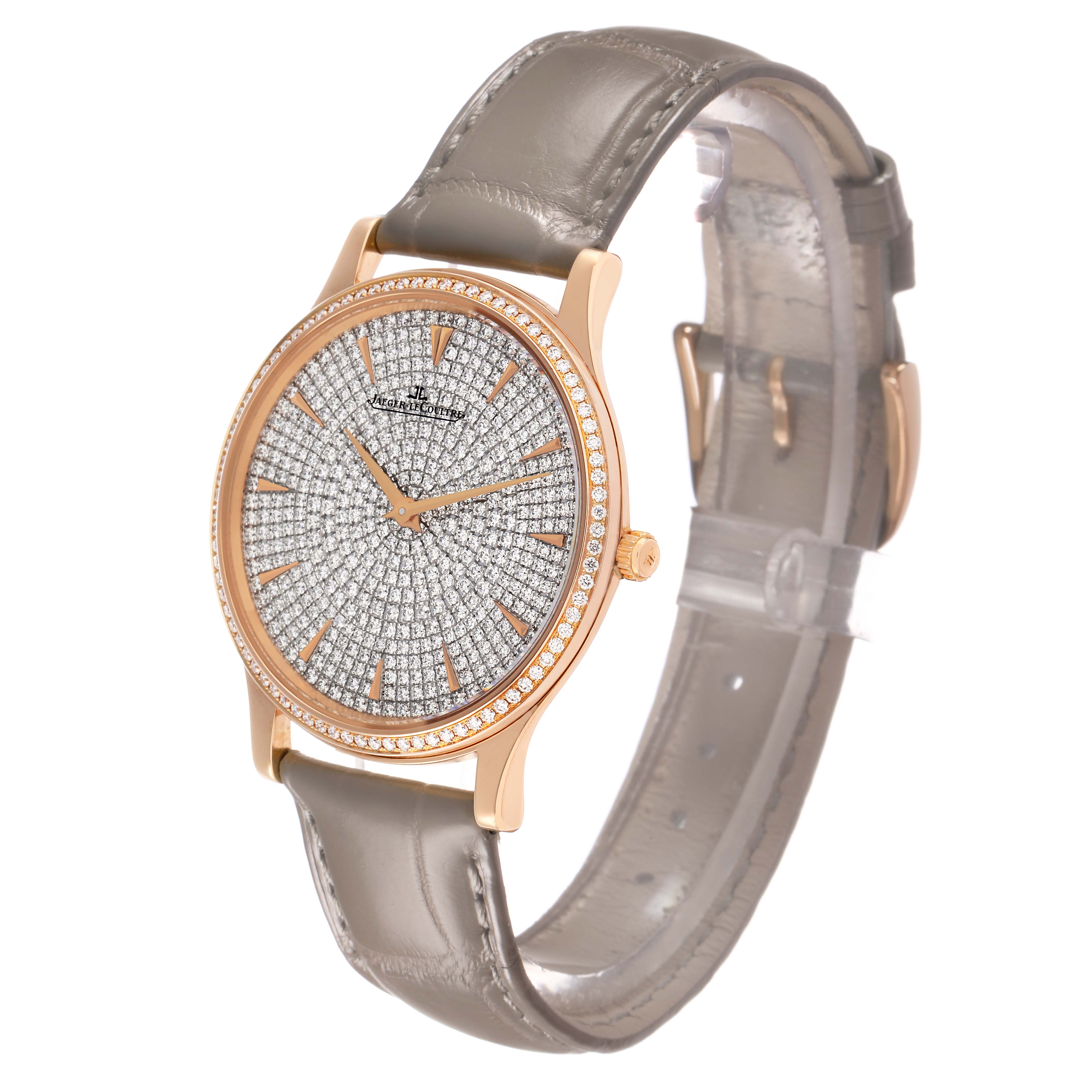 The Jaeger LeCoultre Master Q1452507 Women's Rose Gold Silver Dial model watch is shown at a slight side angle, displaying its diamond-studded dial and gold case with a gray leather strap.